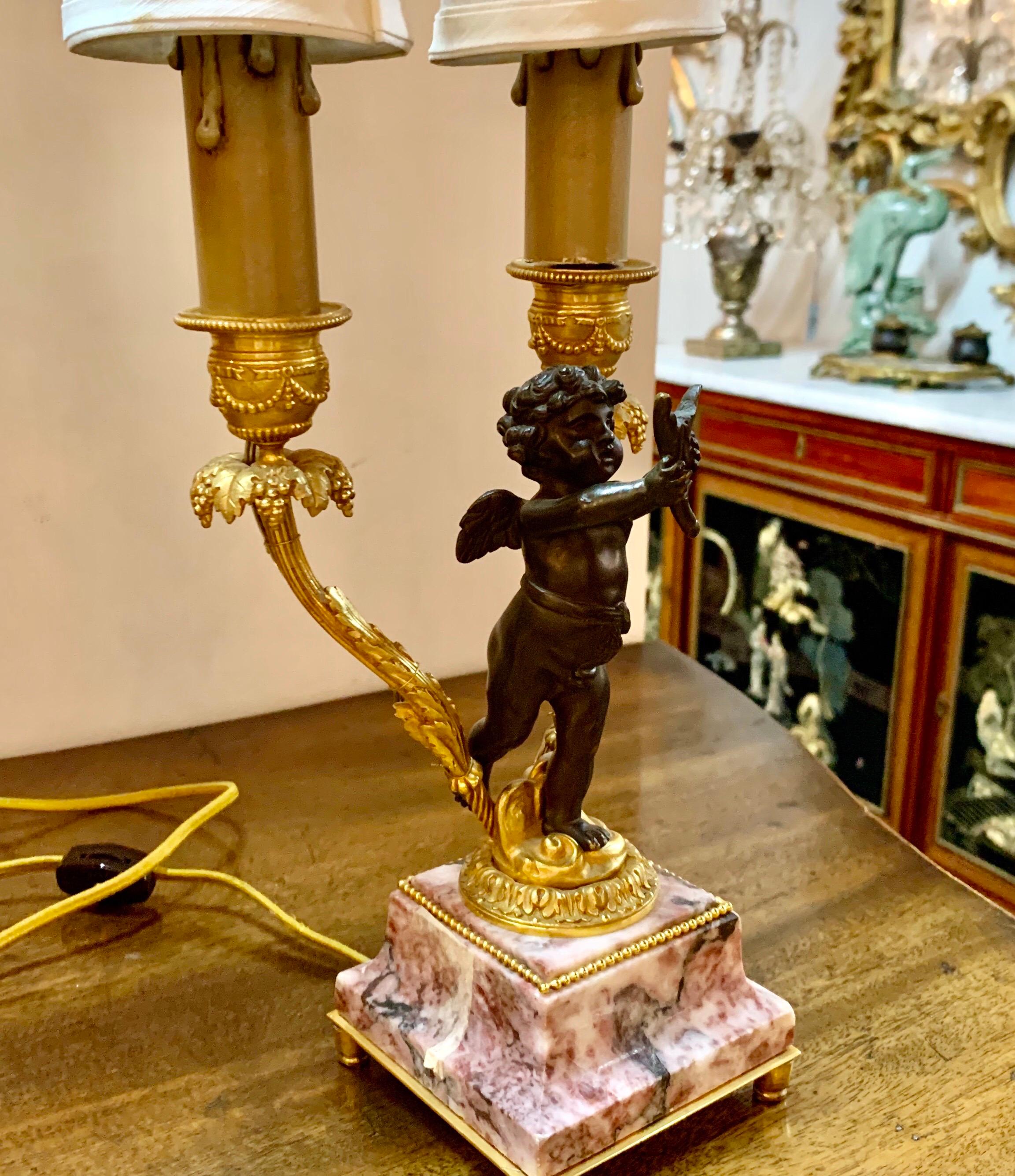Beautiful 19th century French bronze cherub lamp on marble base. Gorgeous decorative details on the bronze candlesticks and a lovely cherub form makes this a unique piece! Wired and ready for you. So pretty!