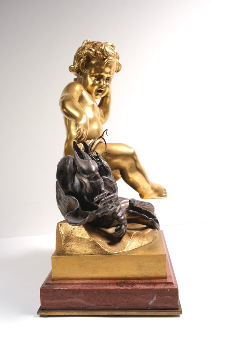 Dore bronze and silvered bronze cherub on rouge marble base. Lobster motif. Signed by artist Pegale. Very finely detailed.