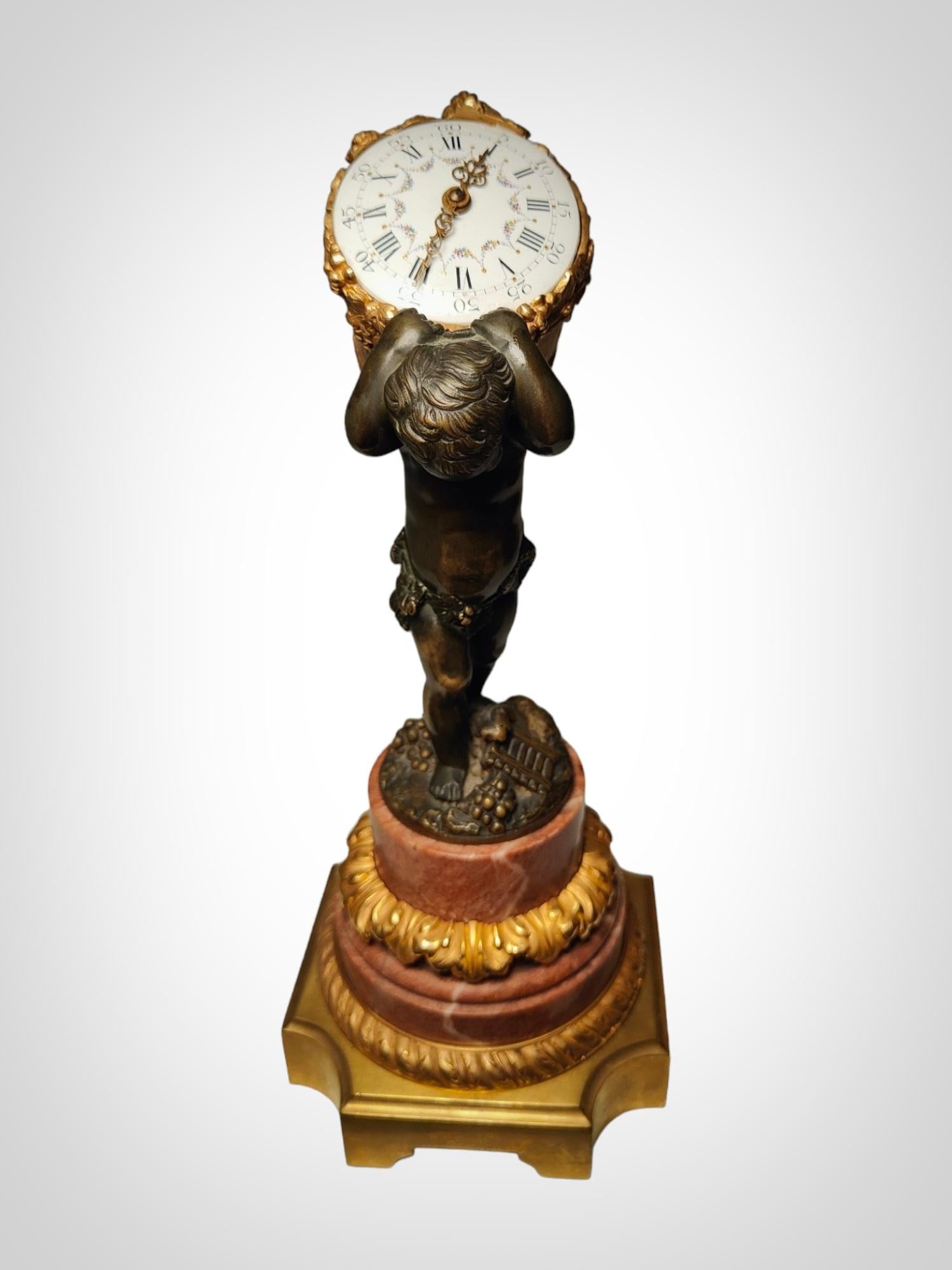 Transport your space to the 19th century with this elegant French bronze clock, adorned with gilding and patina, depicting a cherub, an allegory of the harvest. This clock is a masterpiece both in design and functionality. Resting on a beautiful red