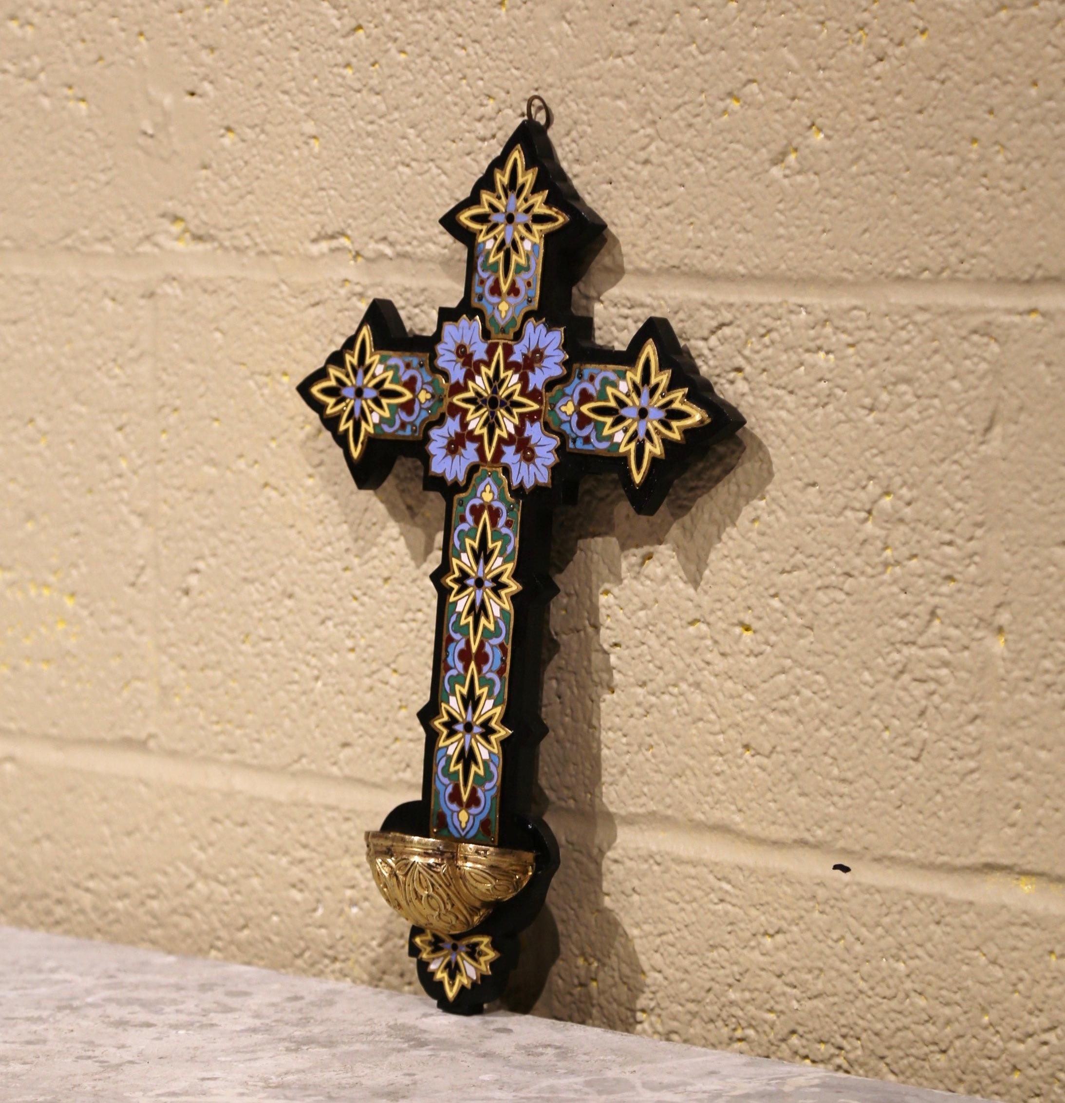 This colorful cross with holy water font recipient was created in France, circa 1880. The large antique cross mounted on a wood plaque, features beautiful, intricate cloisonné work with enamel, stone and bronze star decor throughout. The religious