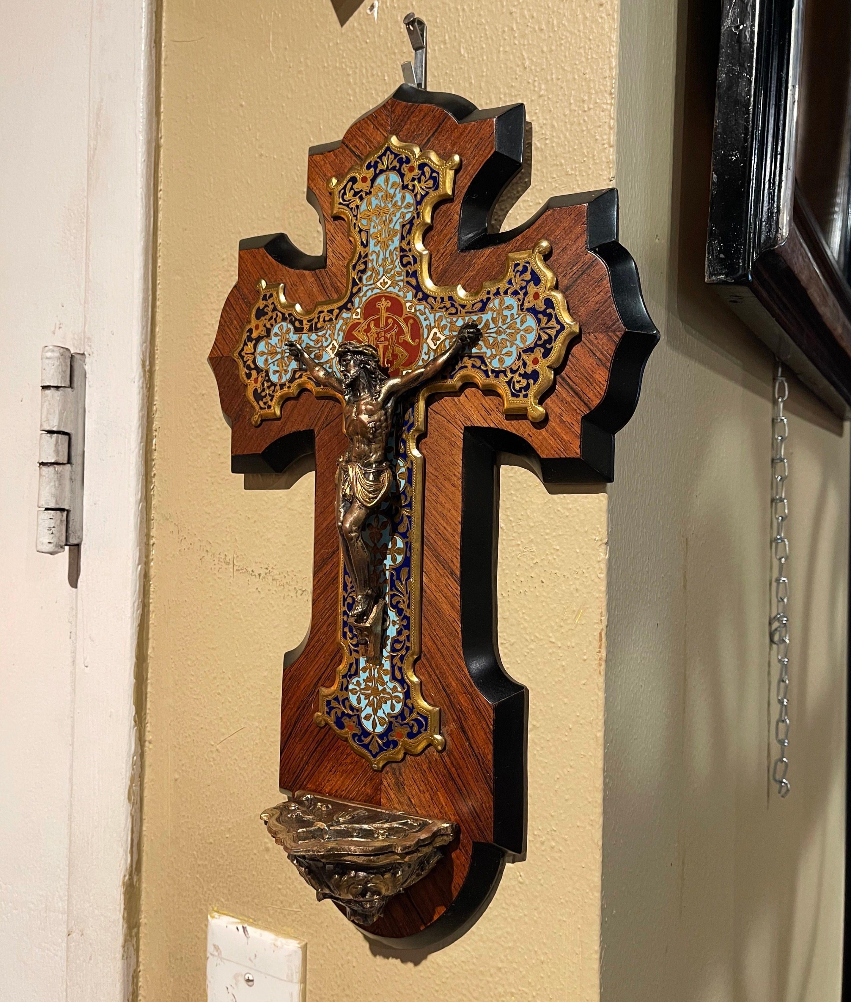 This colorful champleve crucifix with holy water font recipient was created in France, circa 1890. The large antique cross mounted on a marquetry walnut plaque, features beautiful, intricate cloisonné work with enamel, stone and bronze star decor