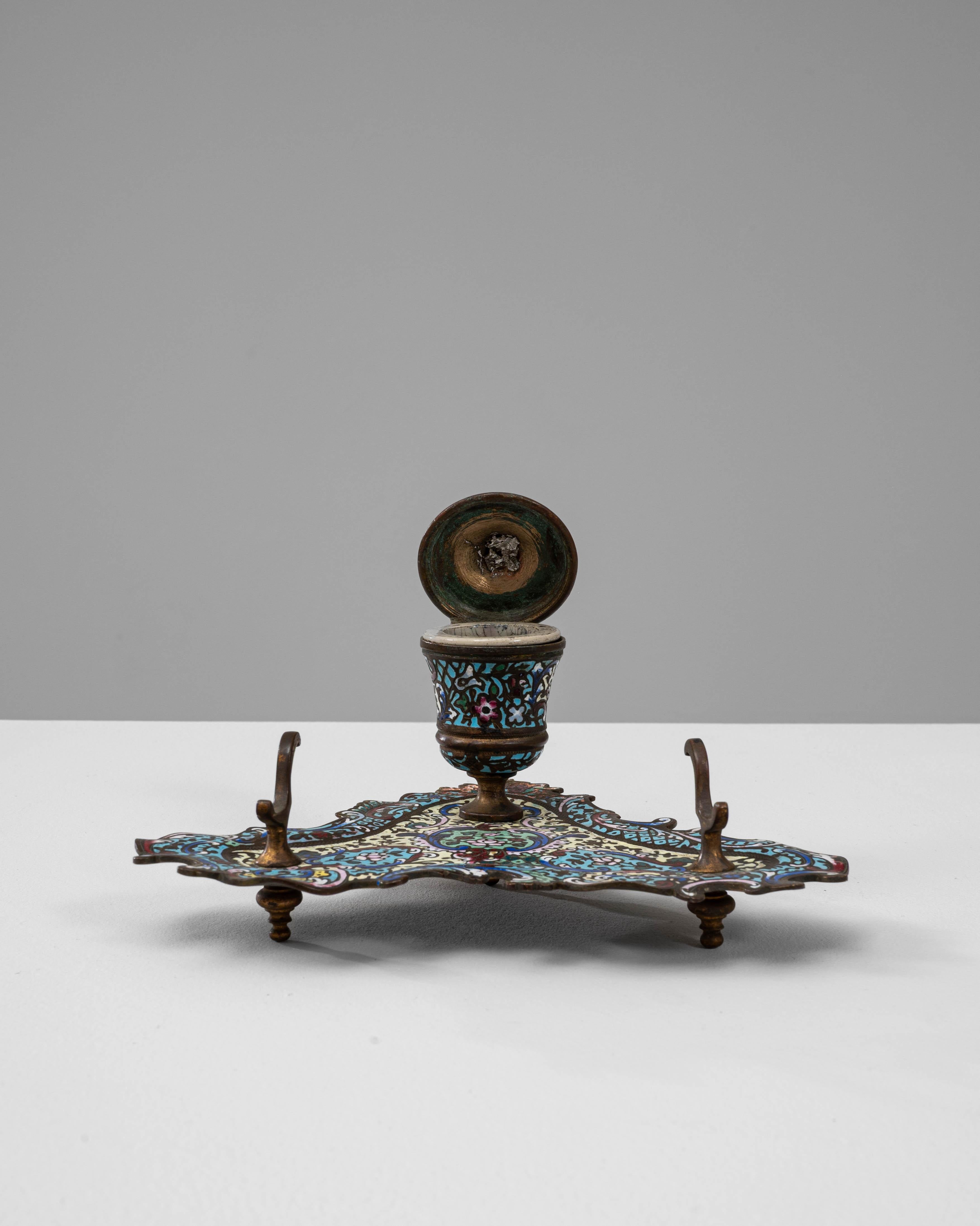 Calamaio da tavolo francese del XIX secolo in bronzo. Questo calamaio ornato esemplifica la raffinata maestria della metallurgia decorativa francese del XIX secolo, combinando un'intricata lavorazione artigianale con vivaci dettagli in smalto. La