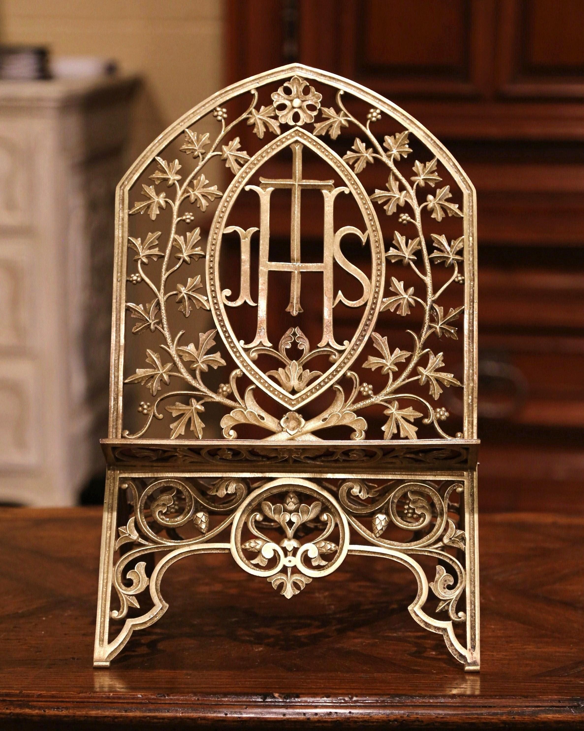 Display your Bible or music sheet on this antique bronze stand! Crafted in France, circa 1860, the folding book holder sits on four small feet and features an adjustable arched facade decorated with intricate floral motifs; it is further embellished