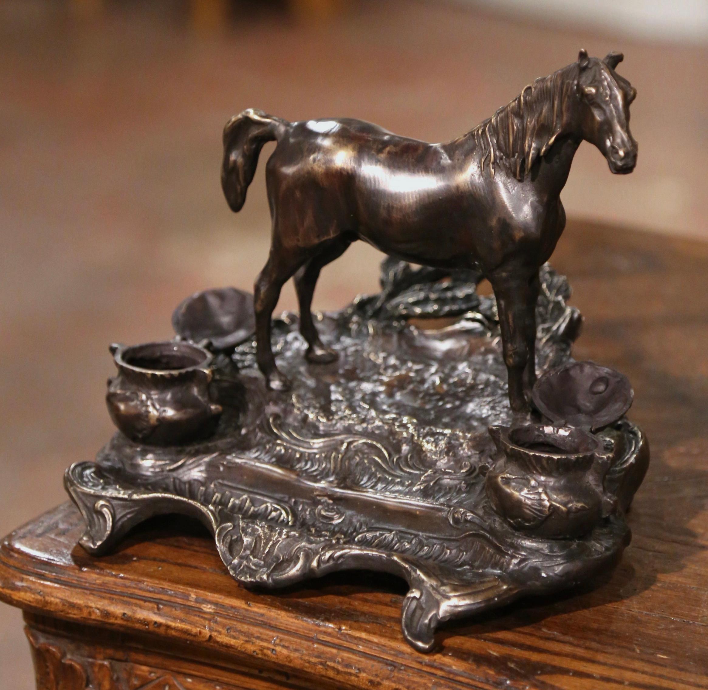 Place this elegant antique signed inkwell in a man’s office. Created in France, circa 1870, the bronze desk accessory sits on four small curved feet, and features a tall horse figure standing on a mount flanked with two round ink holders and lids,