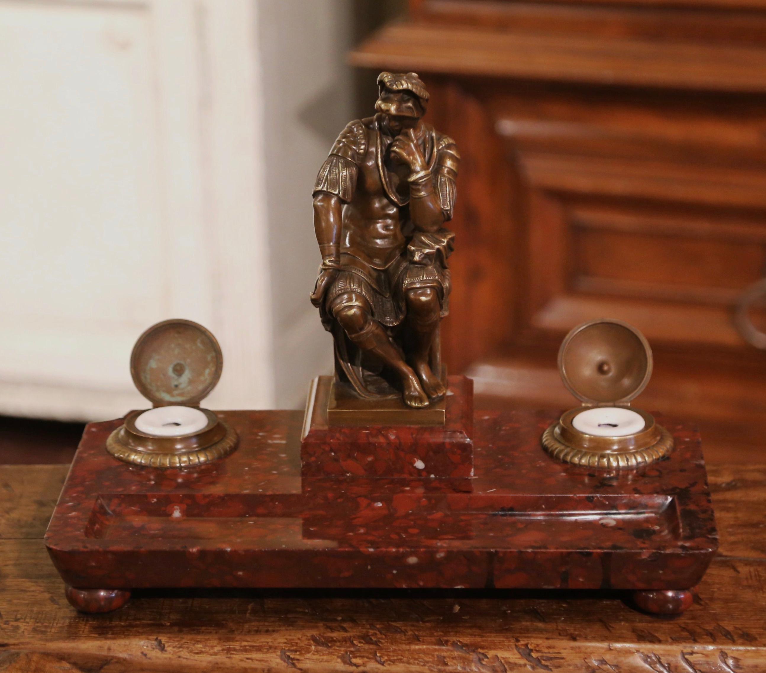 Decorate your office desk with this large Empire style inkwell. Created in France circa 1870 and rectangular in shape, the inkwell features a bronze Roman soldier in the center sitting on a stool. On either side of the figure, are two bronze