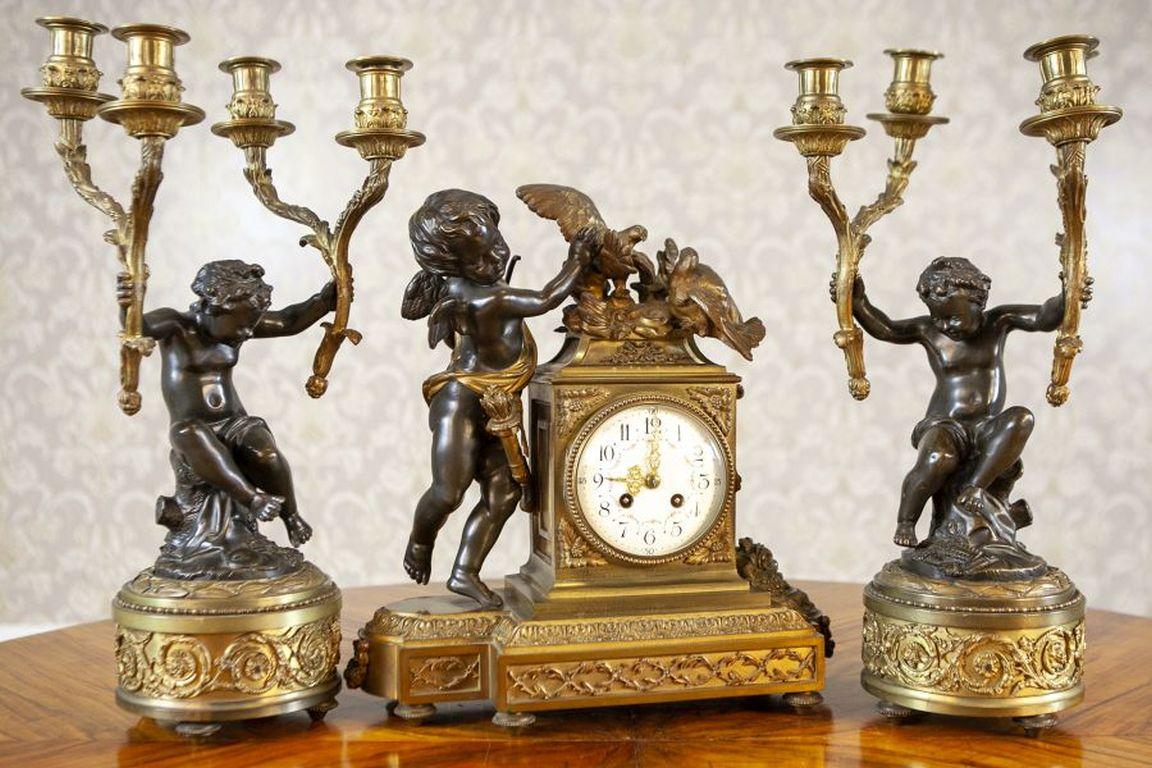 Napoleon III French Bronze Mantel Clock Set from the 19th Century

A figural set featuring putti, known as a mantel clock set, consisting of a mantel clock and two four-armed candelabra. The putti are made of bronze, while the other elements are