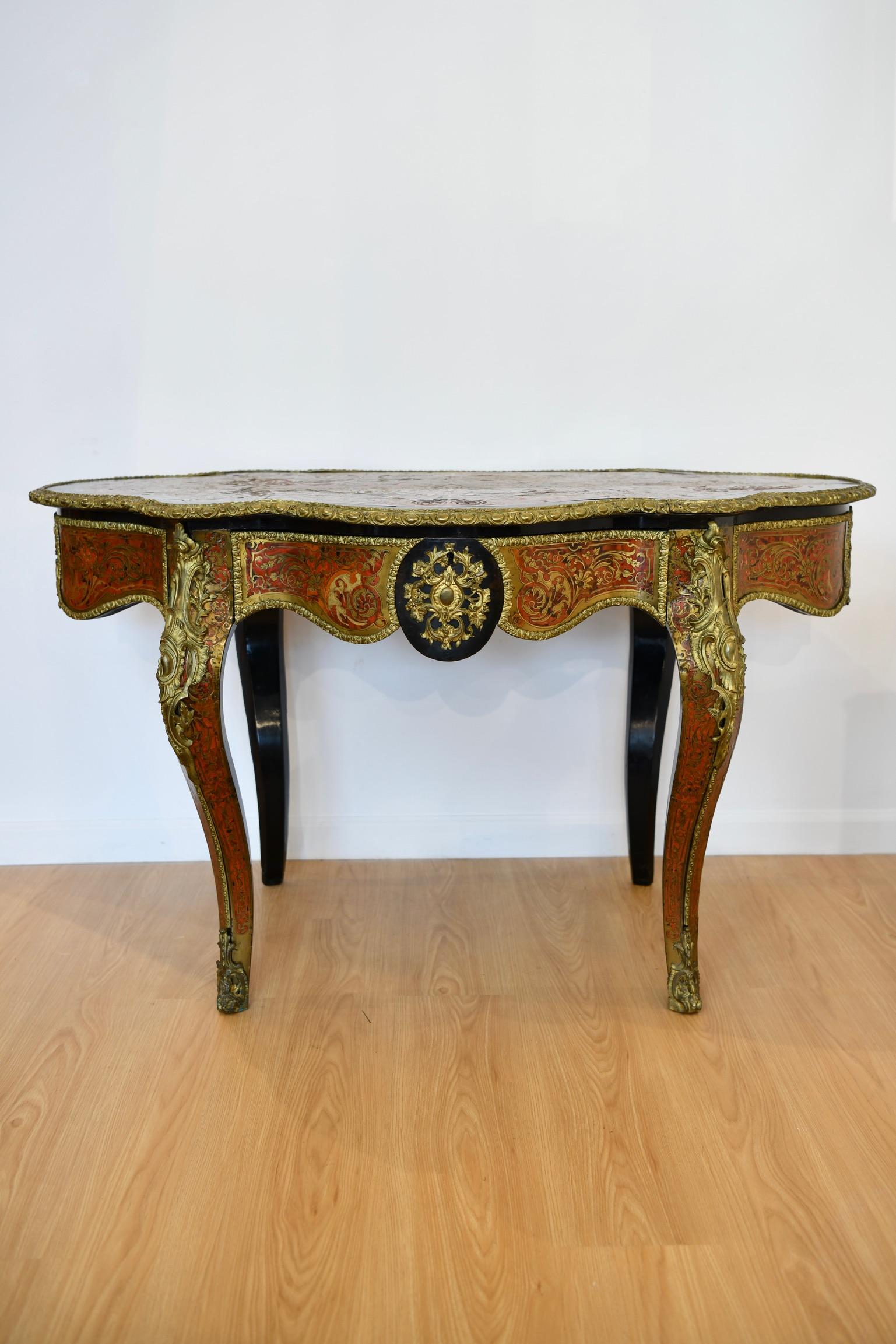 19th century French ebonized center table with bronze accents and mounts throughout. Marquetry work is present to the top and sides of the table. Gilt bronze mounts cover the top's edges and each side features an intricate bronze center. One side