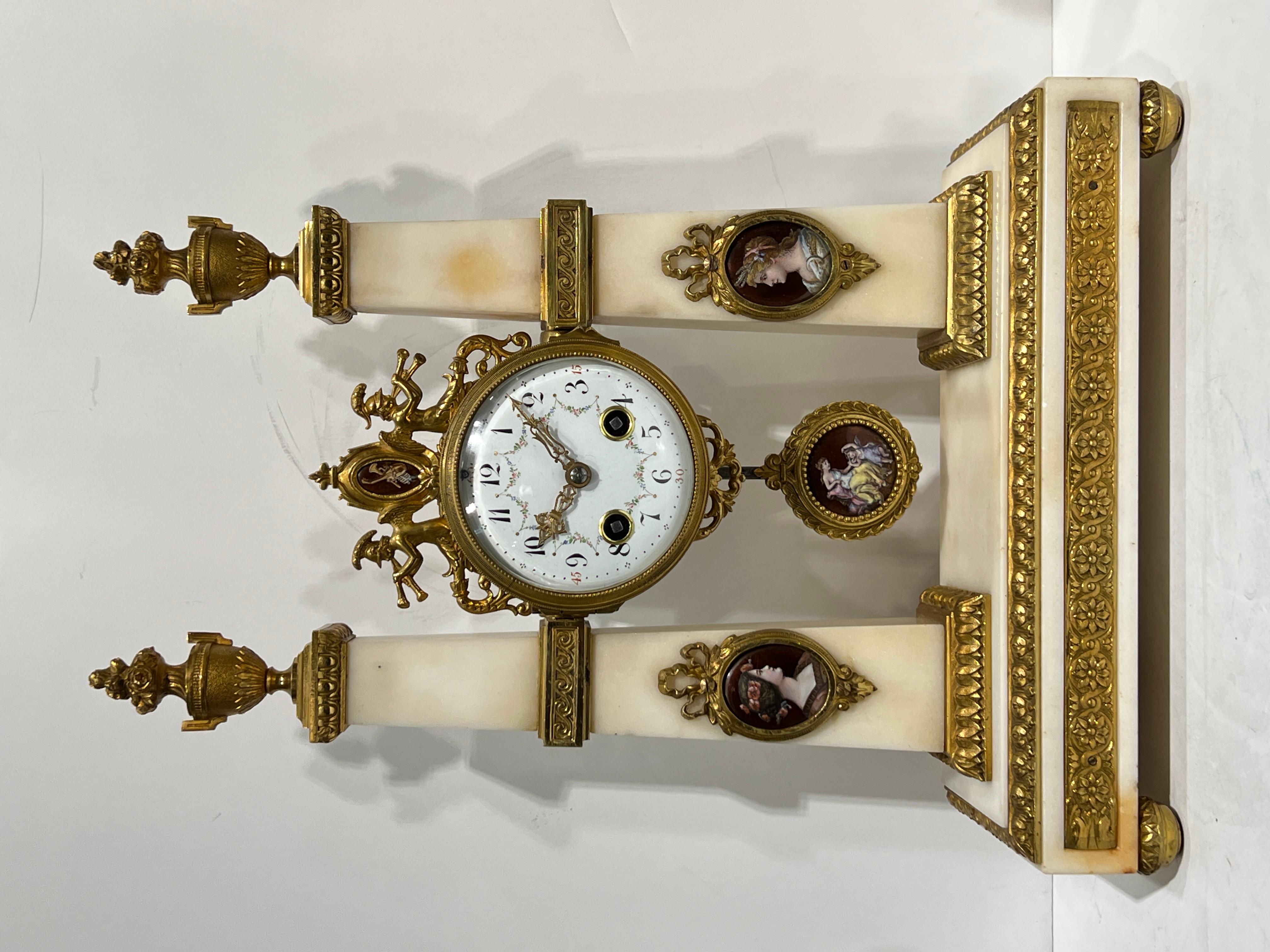 Un'insolita e raffinata decorazione in stile Antique French (XIX secolo), che comprende un orologio da caminetto e una coppia di candelabri a due luci in stile neoclassico, finemente realizzati in pietra d'onice con montature in bronzo dorato e