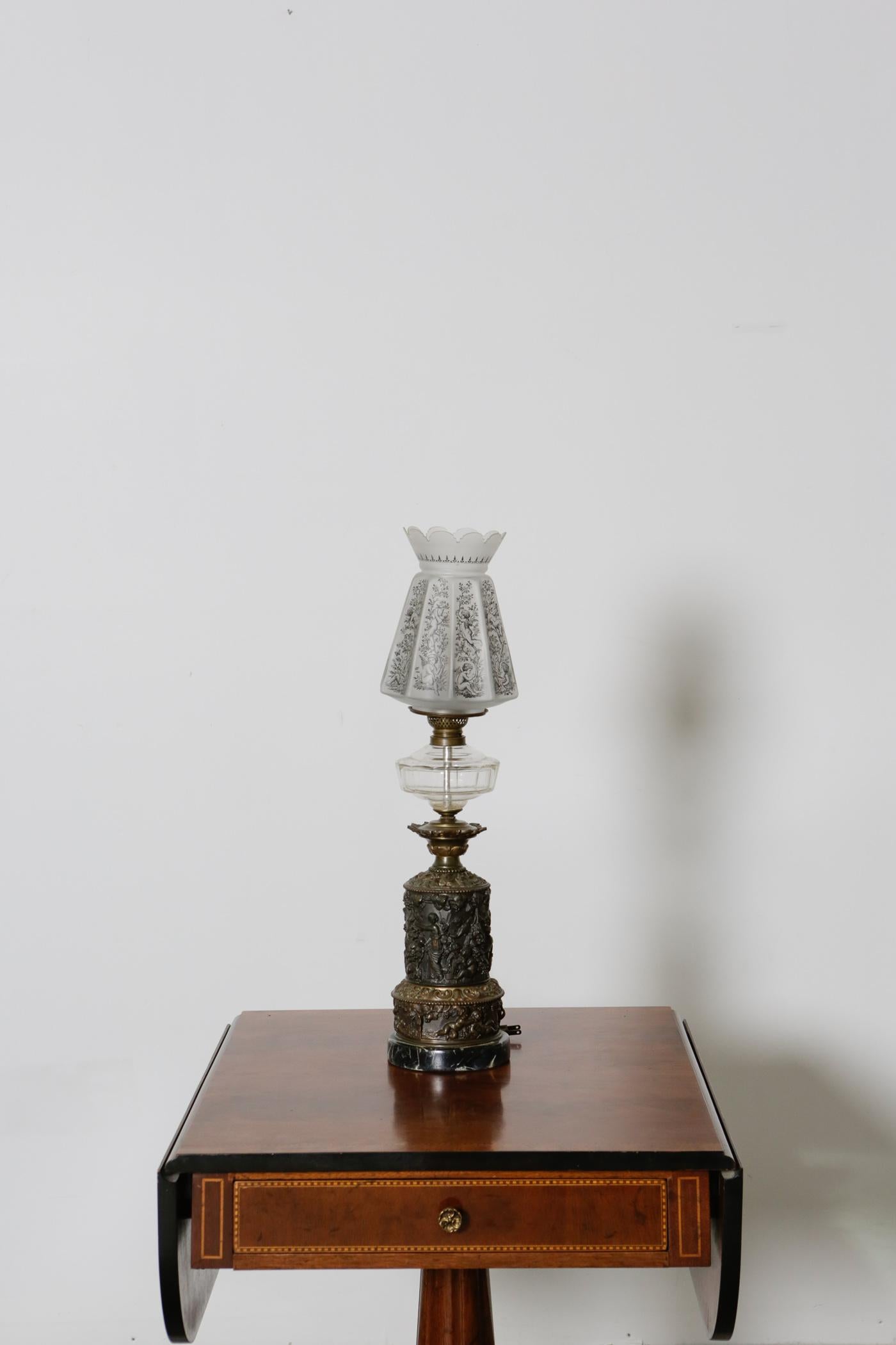 19th century French bronze oil table lamp with frosted glass shade.

This highly detailed elegant bronze antique oil lamp is complemented with an angelic floral frosted glass shade. Rare and true antique piece with full of history. This will add a