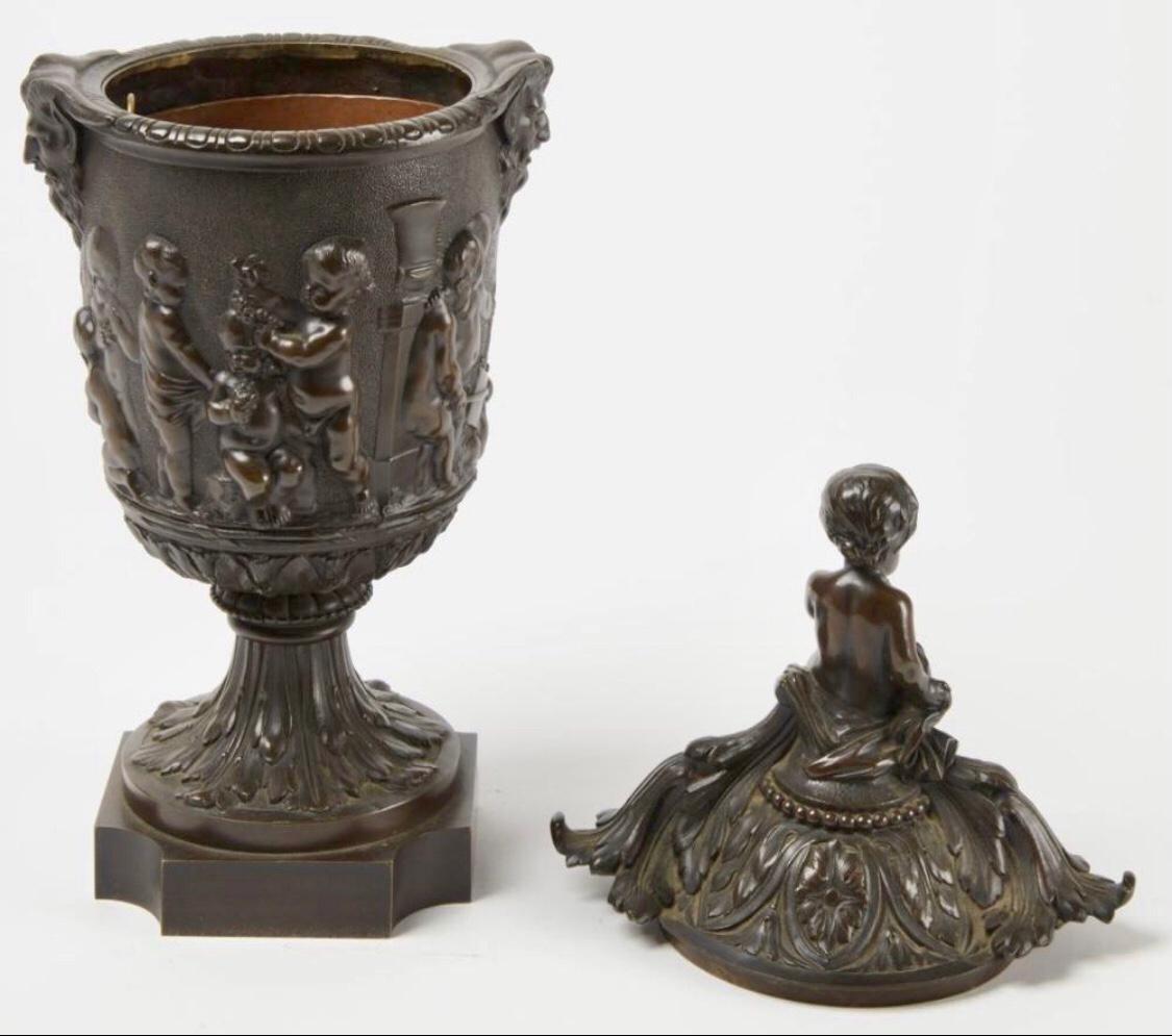 Very nice French cast bronze urn with lid and copper insert featuring putti and Bacchus, 19th century, great patina. Measuring: 17