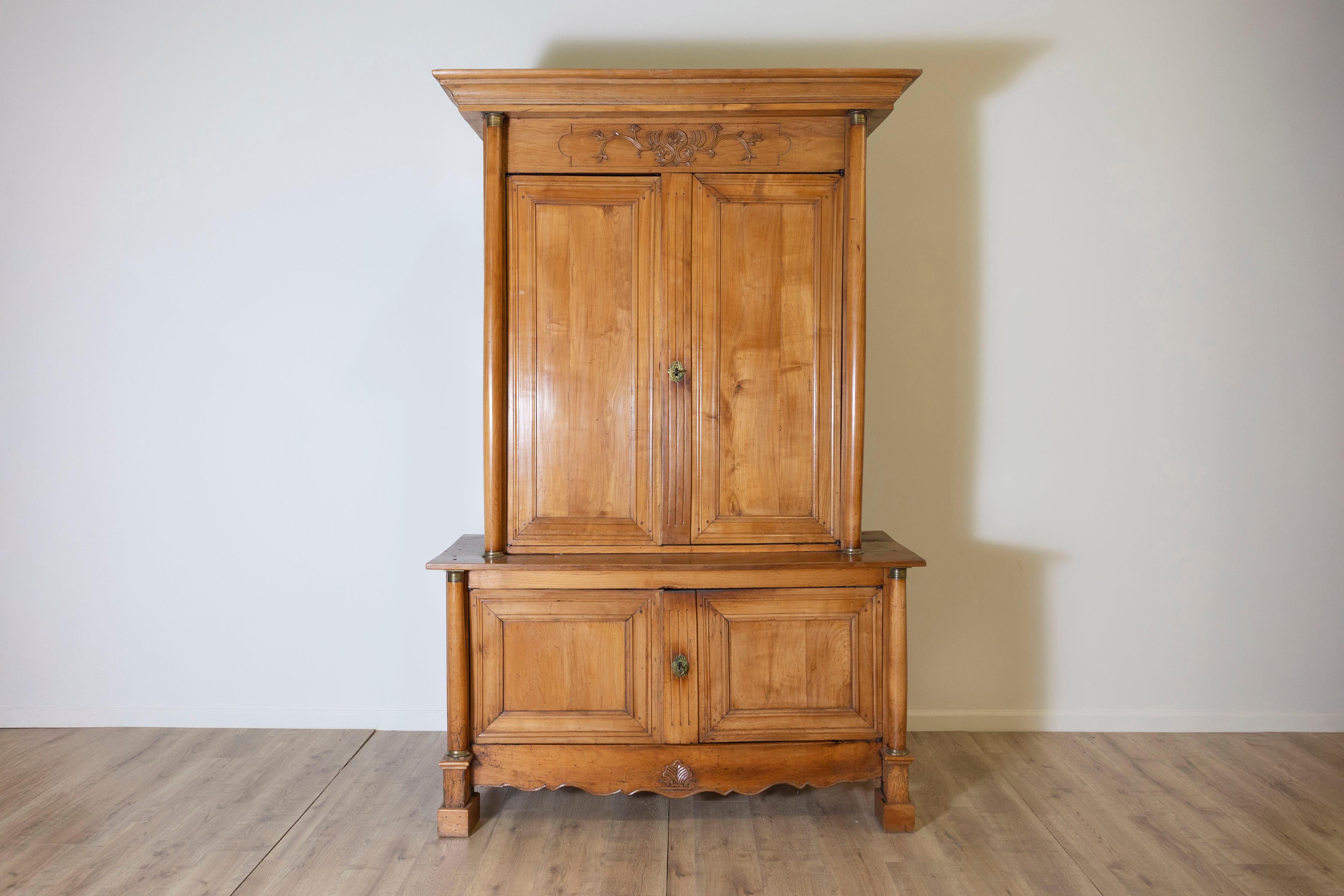 Ein hübsches französisches Buffet deux corps aus dem 19. Jahrhundert aus massivem Obstholz mit einer warmen, honigfarbenen Patina. Dieser zweiteilige Schrank zeichnet sich durch einen wunderschön geschnitzten Fries aus, der mit floralen und