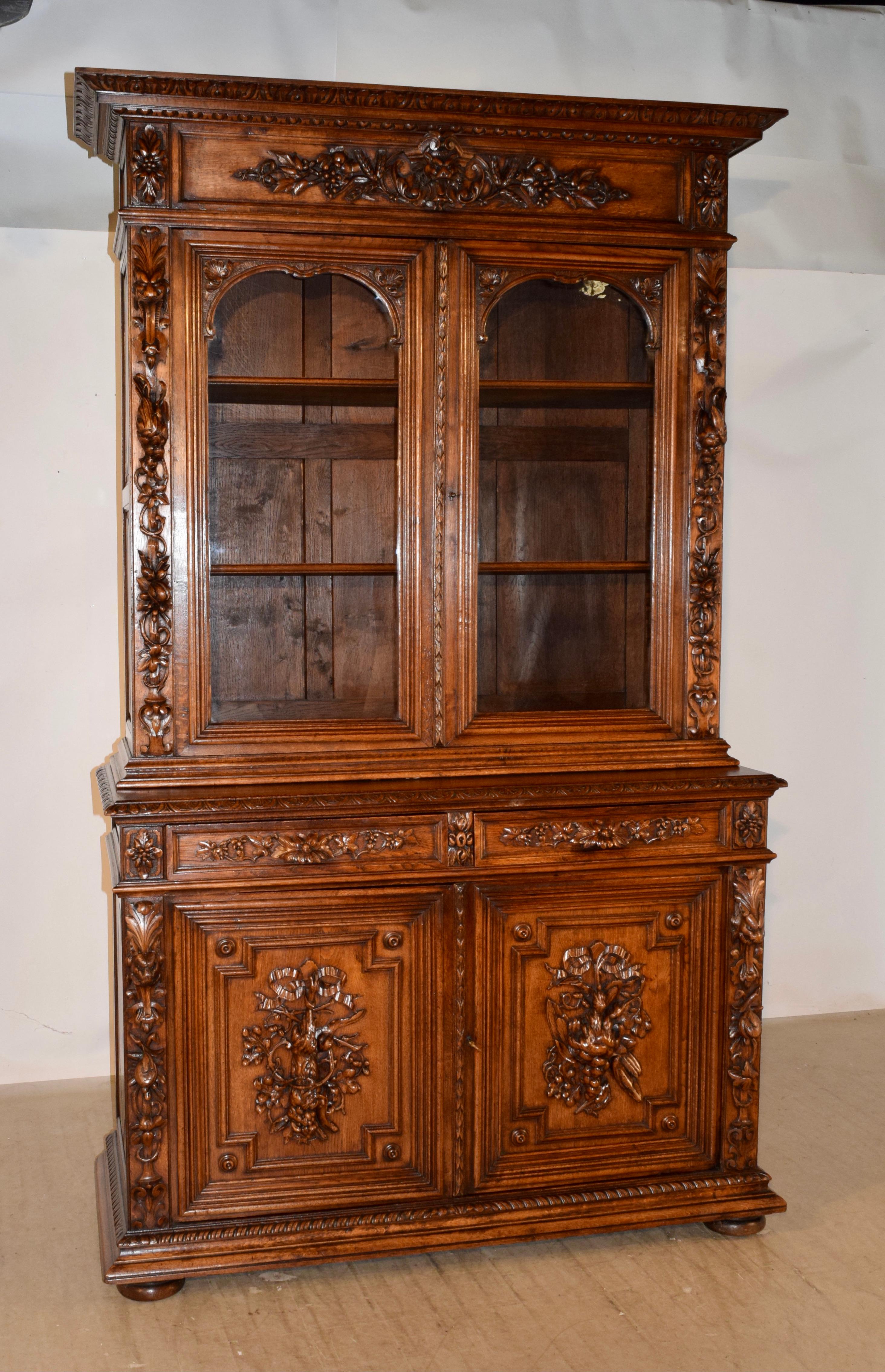 Buffet deux corps en chêne du XIXe siècle, exceptionnellement bien sculpté, provenant de France. Ce meuble en deux parties présente une merveilleuse couronne décorée sculptée à la main sur un magnifique meuble à portes vitrées avec les portes