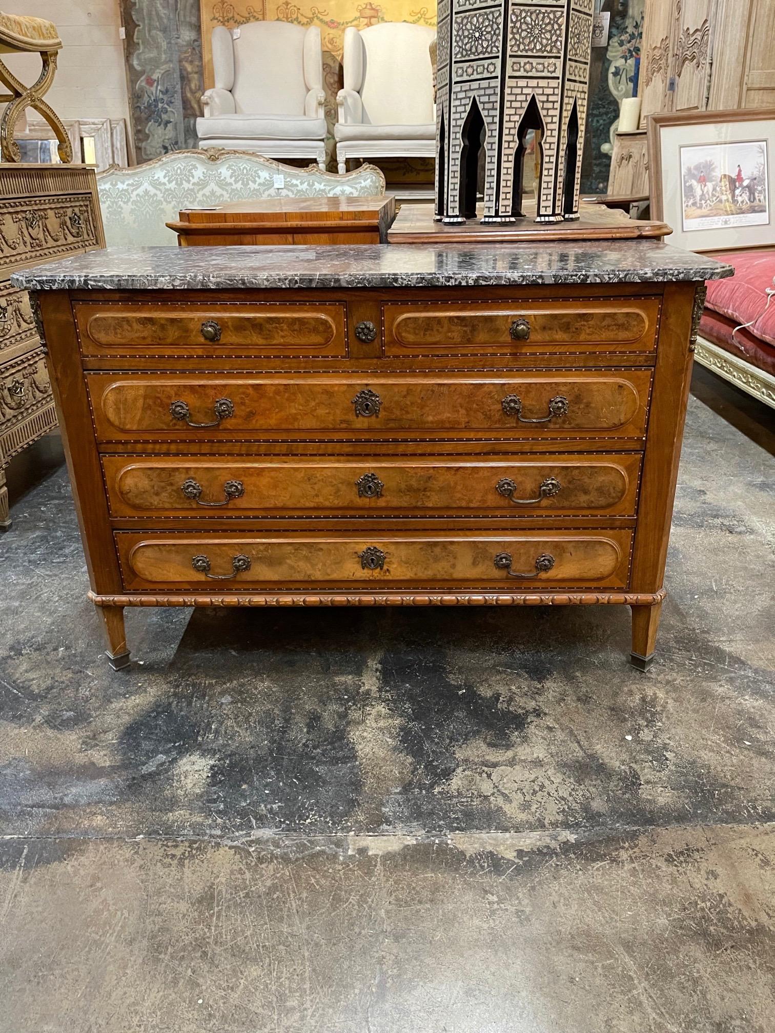 Handsome 19th century French burl walnut commode with inlaid pattern on the doors. The piece also has the original grey marble top and ample storage. Very fine quality!
