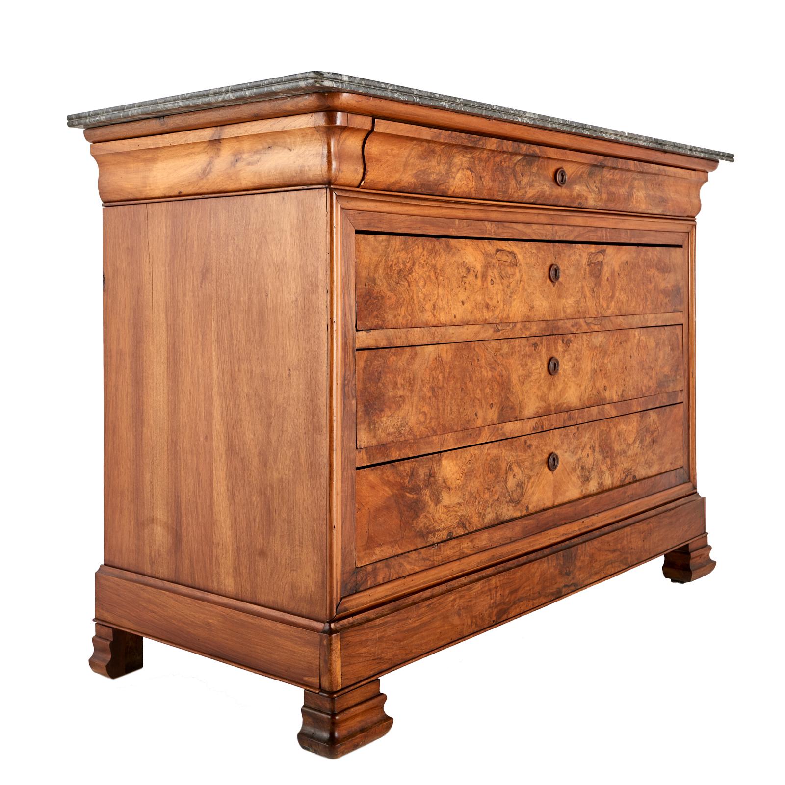 A French walnut Louis Philippe four drawer commode, the drawer fronts veneered in dramatic book-matched burl walnut, the top with its original grey marble top.