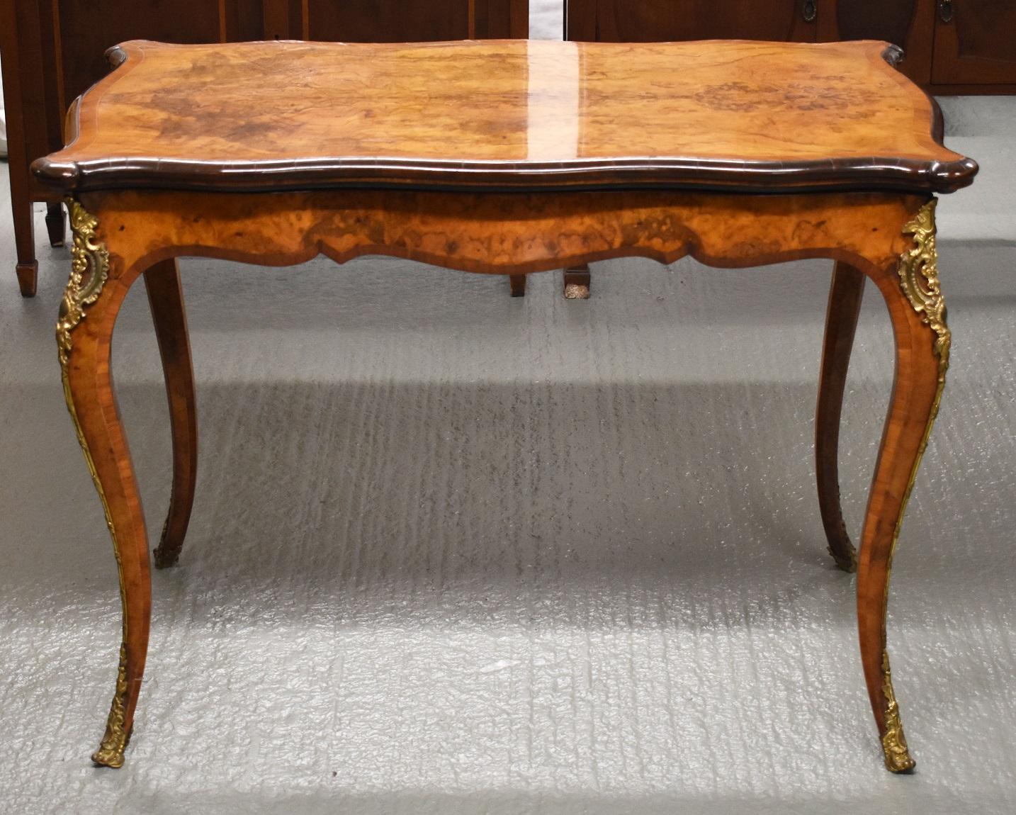 Nous proposons à la vente une table à cartes de très bonne qualité en ronce de noyer du XIXe siècle. Le plateau de la table est orné de bandes sur le pourtour et de moulures transversales. Le plateau pivote ensuite pour révéler un espace de