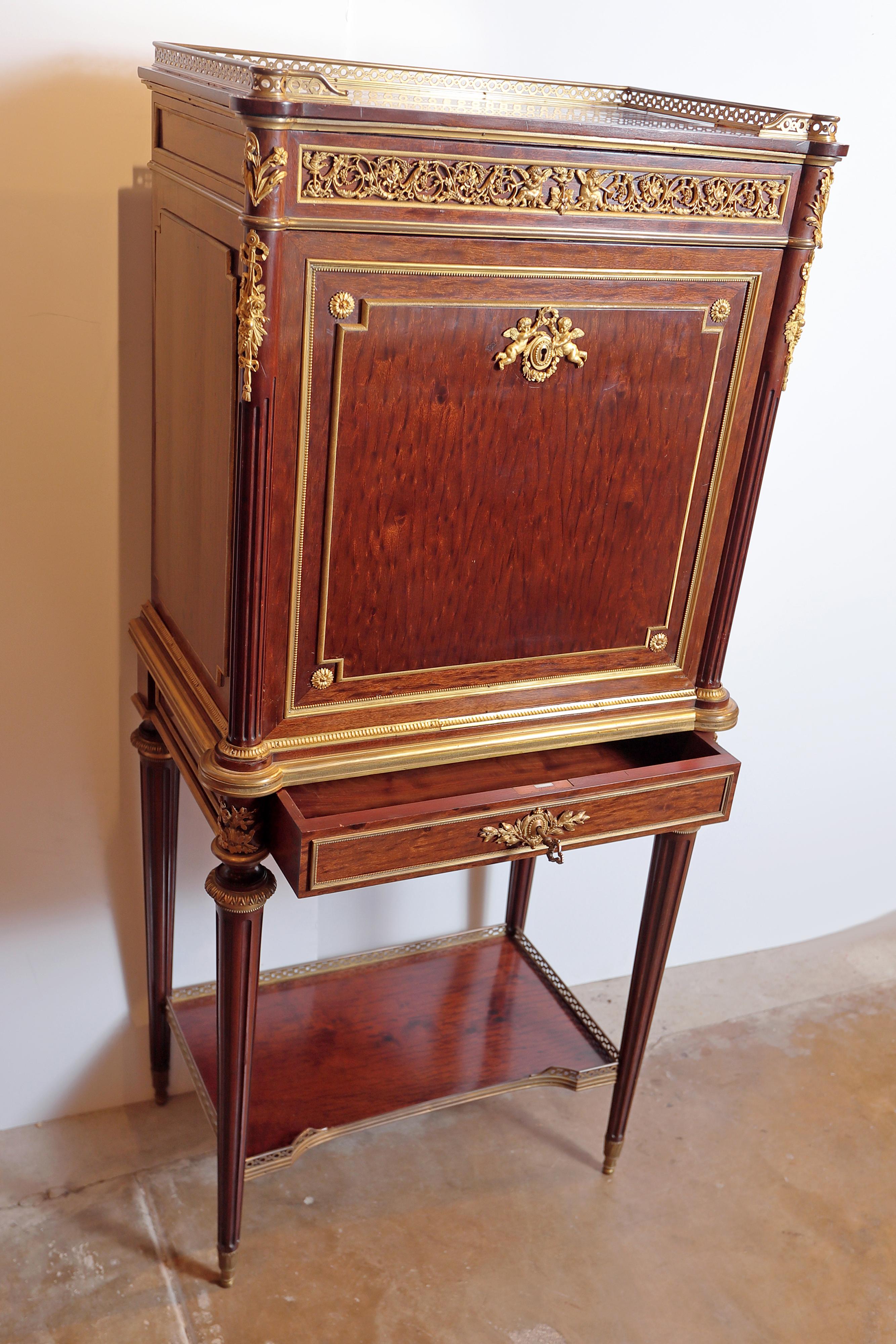 Late 19th century the rectangular three-quarter galleried top with eared corners above the conforming case fitted with a fall-front opening to gilt and tooled leather-inset writing surface and five shelves, further over a drawer, the lock plate
