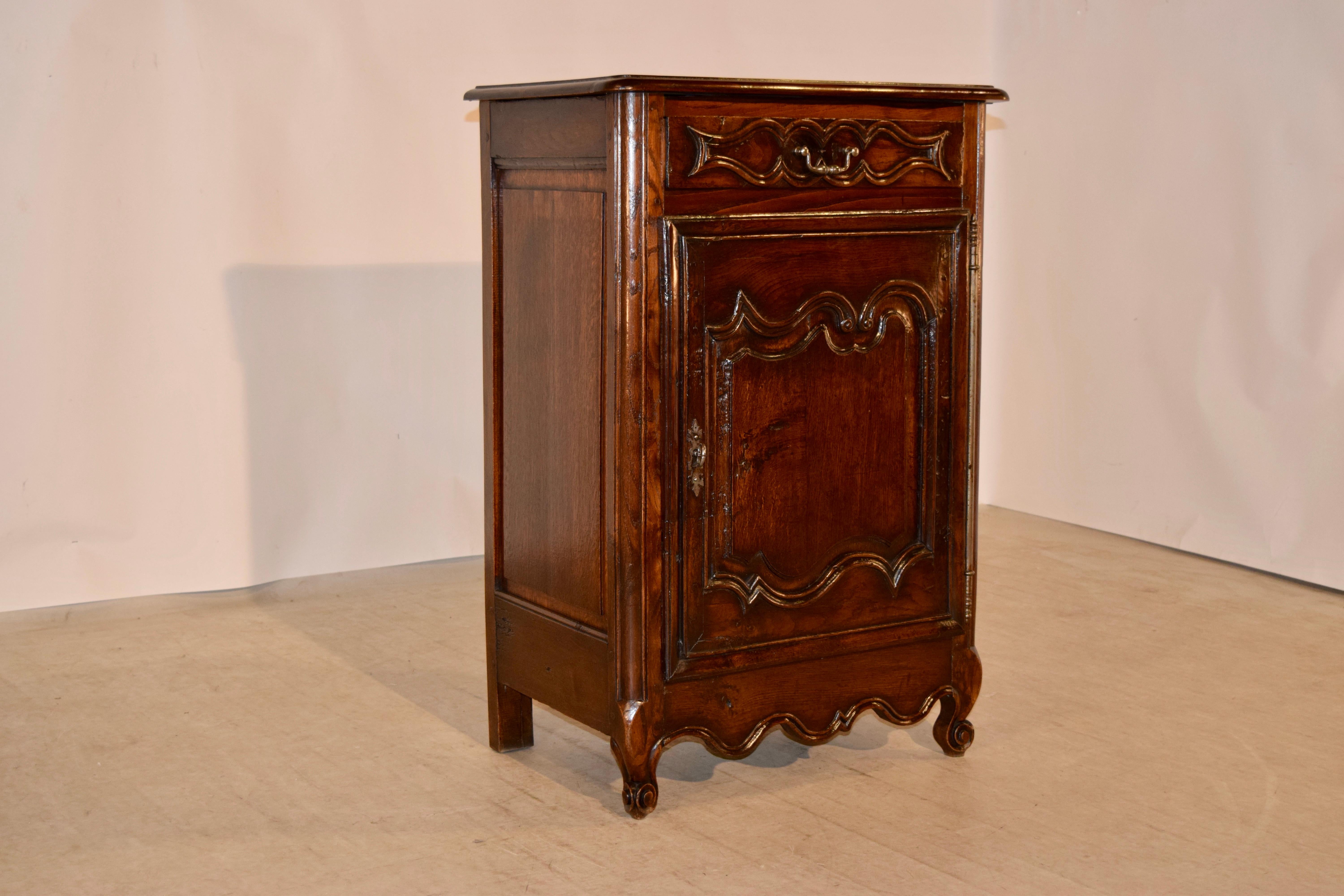 19th century cabinet from France made from oak. The top is banded and has a bevelled edge following down to a single drawer in the front over a single door, which opens to reveal storage. The drawer front and door are hand carved raised panelled.