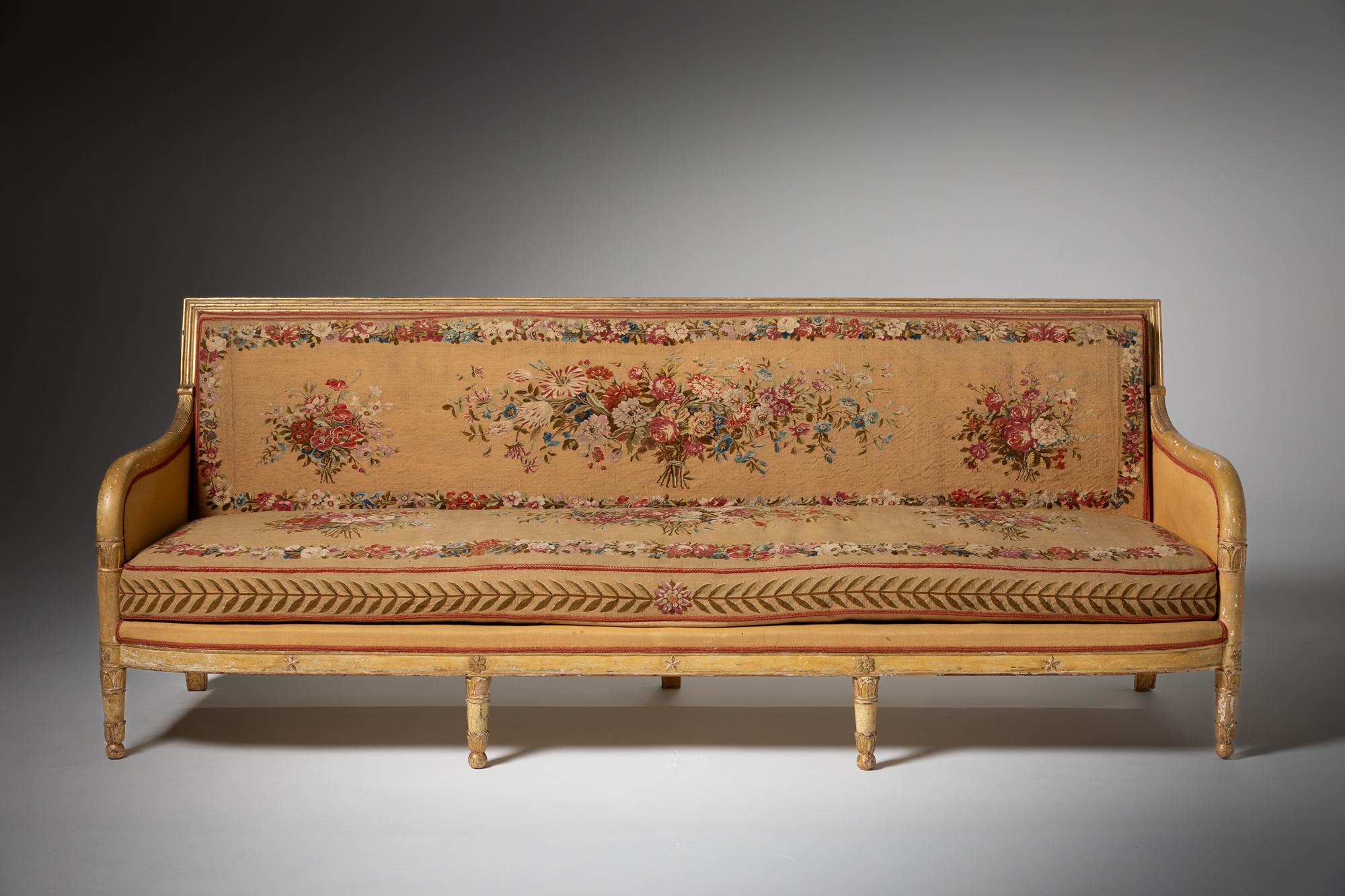 This impressive canapé from 19th-century France exemplifies the elegance and craftsmanship of the era. Measuring generously in size, it features a framework of meticulously carved wood, which has been both painted and gilded to achieve a luxurious