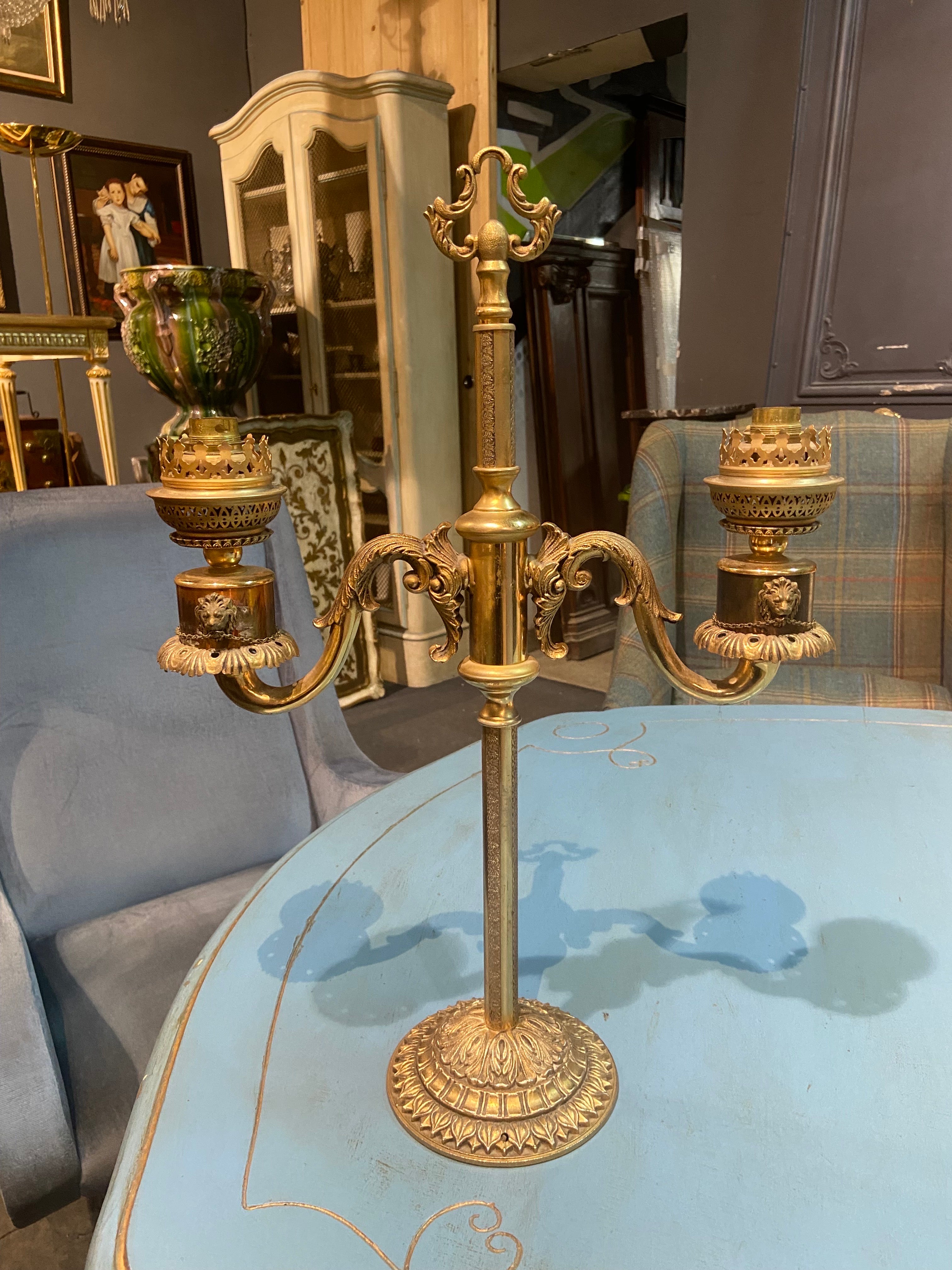 19th century French authentic candlestick electrified in double arm brass lamp.
There are lion's heads on each end and a lovely decoration all around.
The original lampshades are not available.
France, circa 1880.