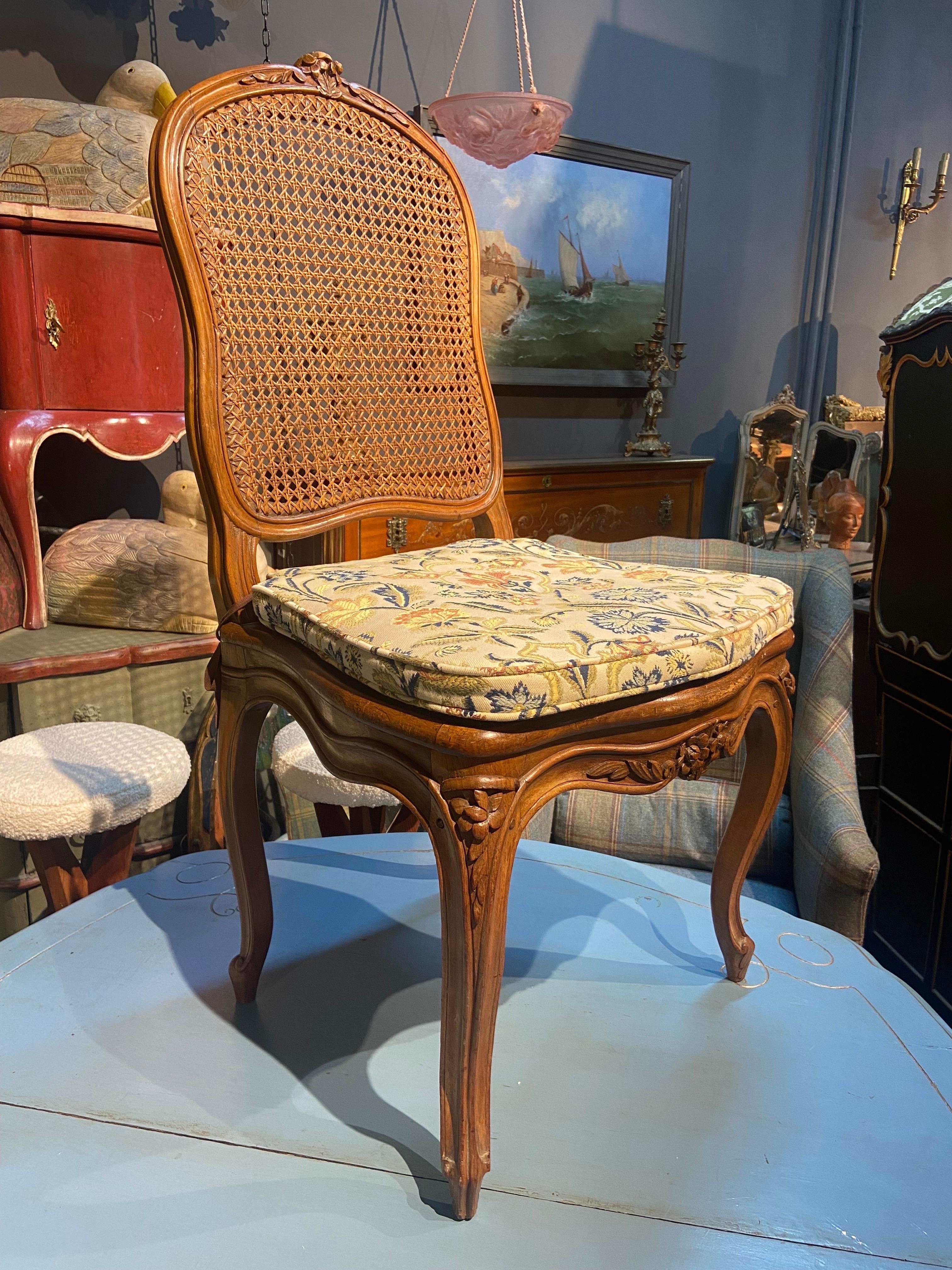 Four French chairs in hand carved walnut frame with seat and back in cane. Very good condition with no restorations. Comfortable and stable construction with cozy pillows on the seats. There are still parts of original labels under the