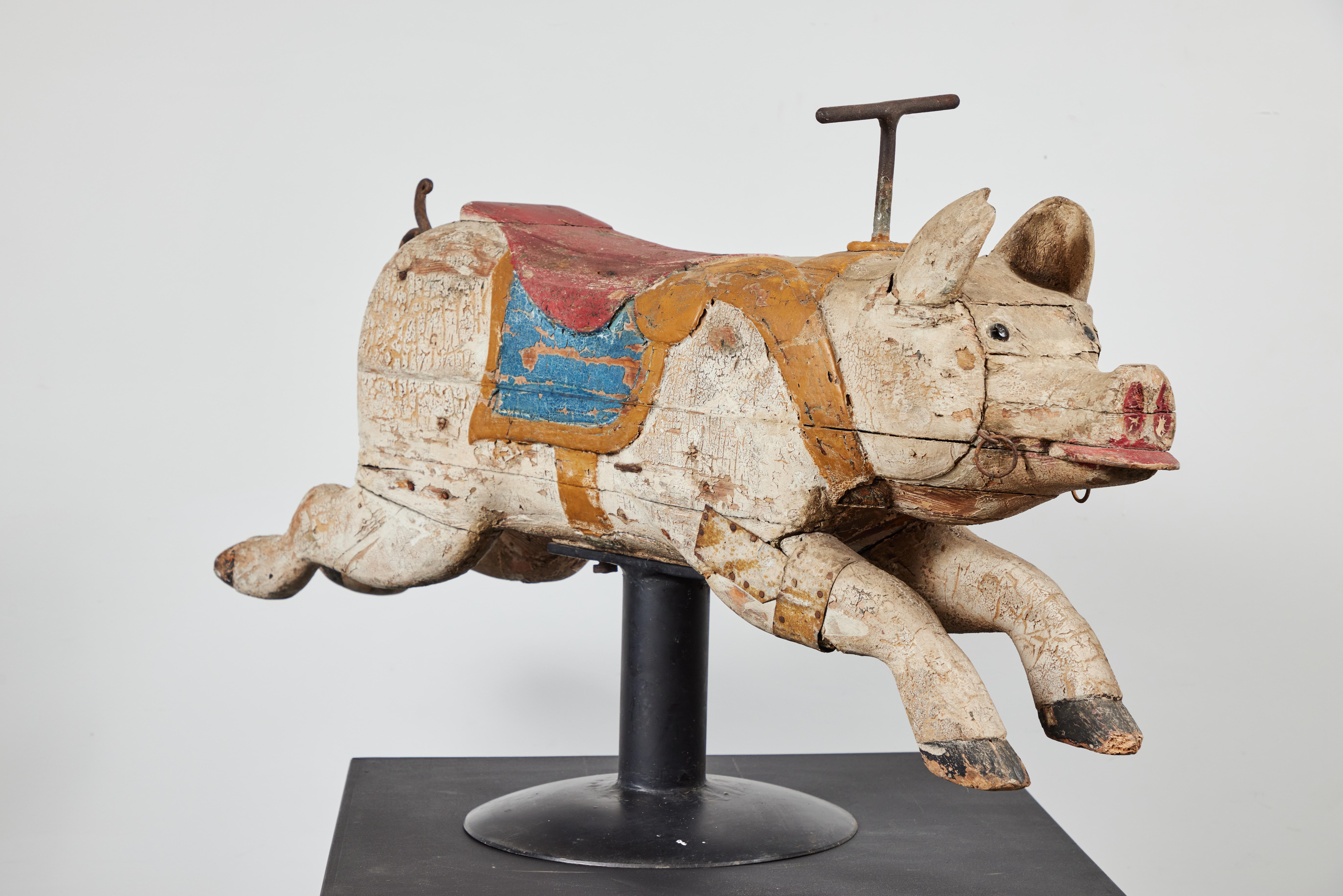Fantastic 19th century carousel pig. Super whimsical carnival piece from a bygone era. Carved wood with cast iron curly tail and handle. Original layers of park paint and glass eyes. Very old metal strap repair around one leg. Super solid and