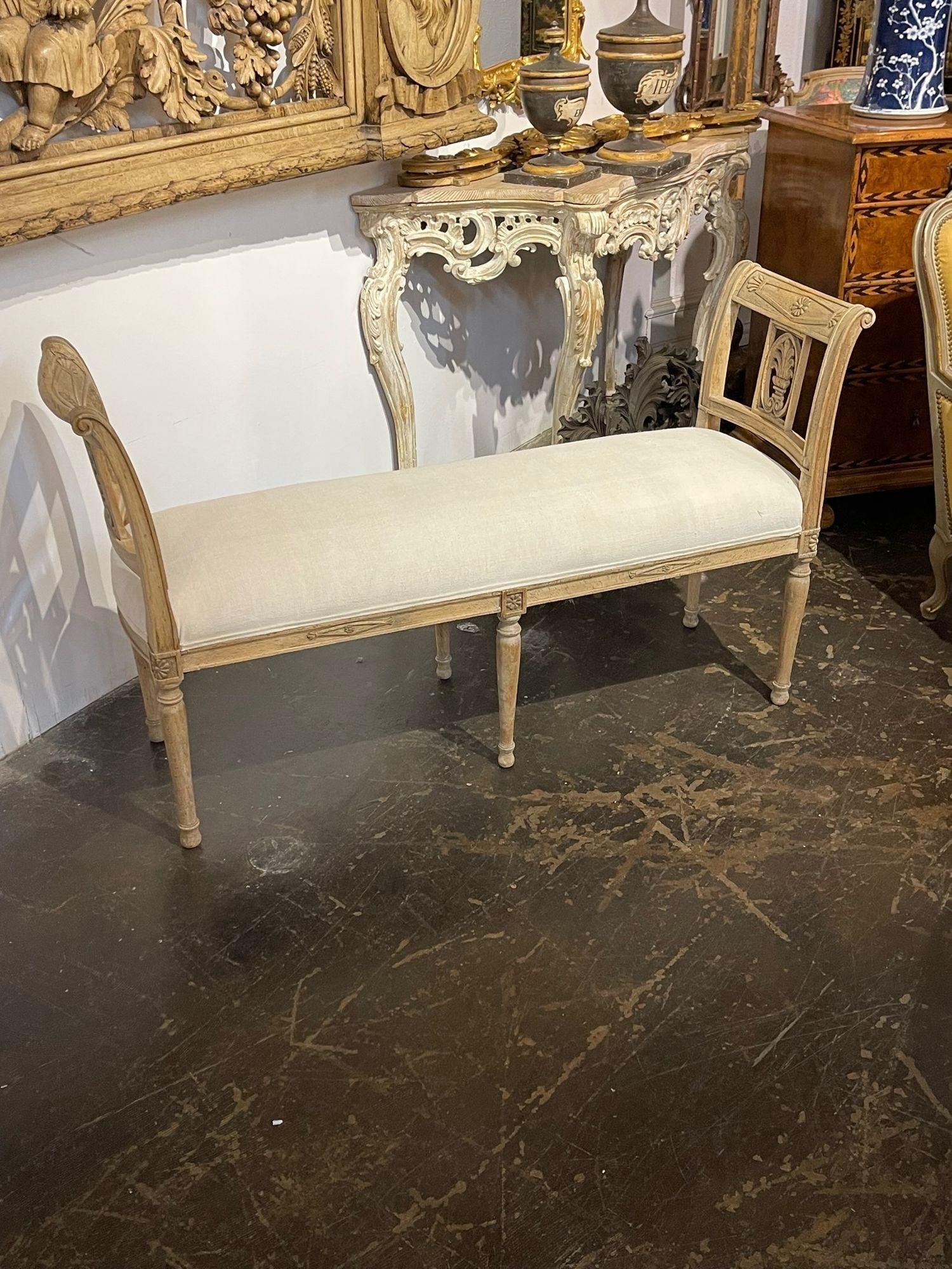 Gorgeous 19th century French Directoire style carved bench with bleached walnut. The piece is upholstered in a lovely creme colored linen upholstery. Very nice!!