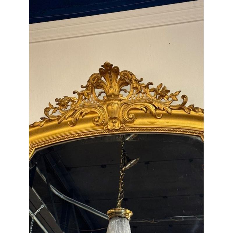 Grande specchio di transizione francese del XIX secolo in legno intagliato e dorato. Caratterizzato da un elaborato stemma con foglie e fiori nella parte superiore. Circa 1870. Una vera opera d'arte!
68h x 41w