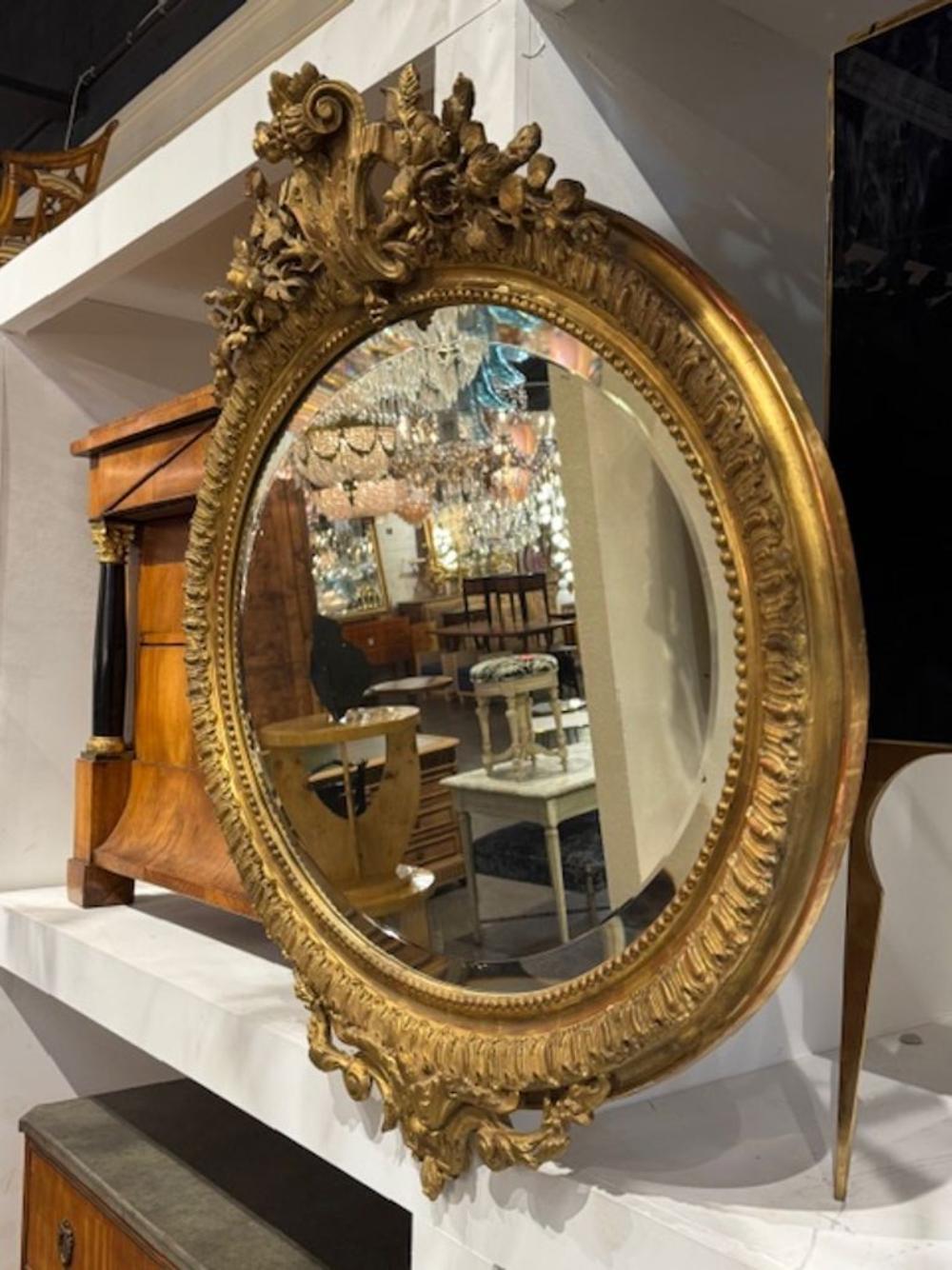 Der ovale Louis-XVI-Spiegel aus dem 19. Jahrhundert ist ein luxuriöses und elegantes Stück.  Die schöne Patina und das geschnitzte Goldholz verleihen jedem Raum einen Hauch von Raffinesse und machen ihn zu einer atemberaubenden Ergänzung für jede
