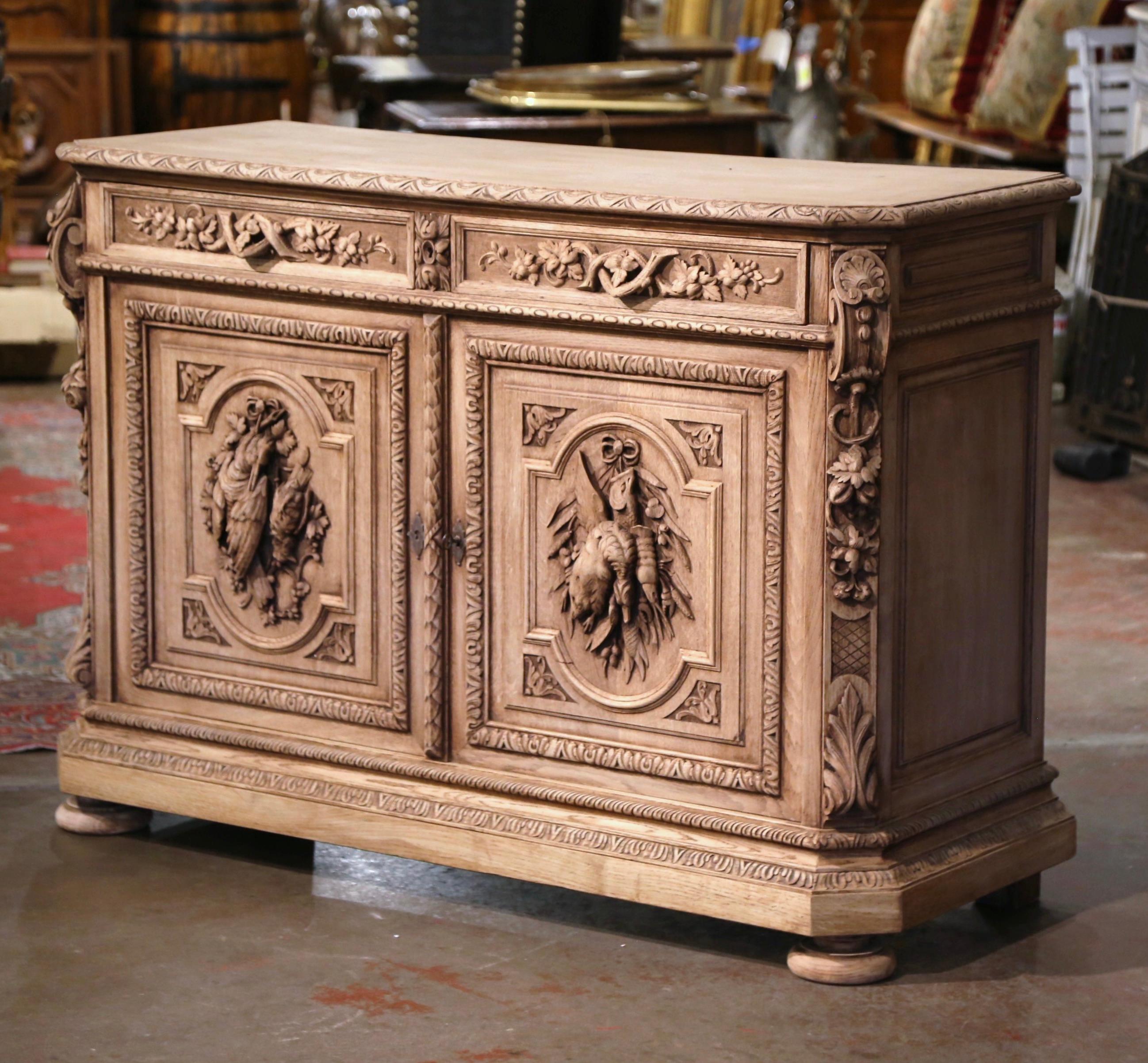 For the ultimate fisherman or bird hunter, look no further than this exquisite buffet! Created in France, circa 1860, the antique cabinet sits on bun feet over a carved recessed base plinth. The buffet with cut corners embellished with acanthus leaf