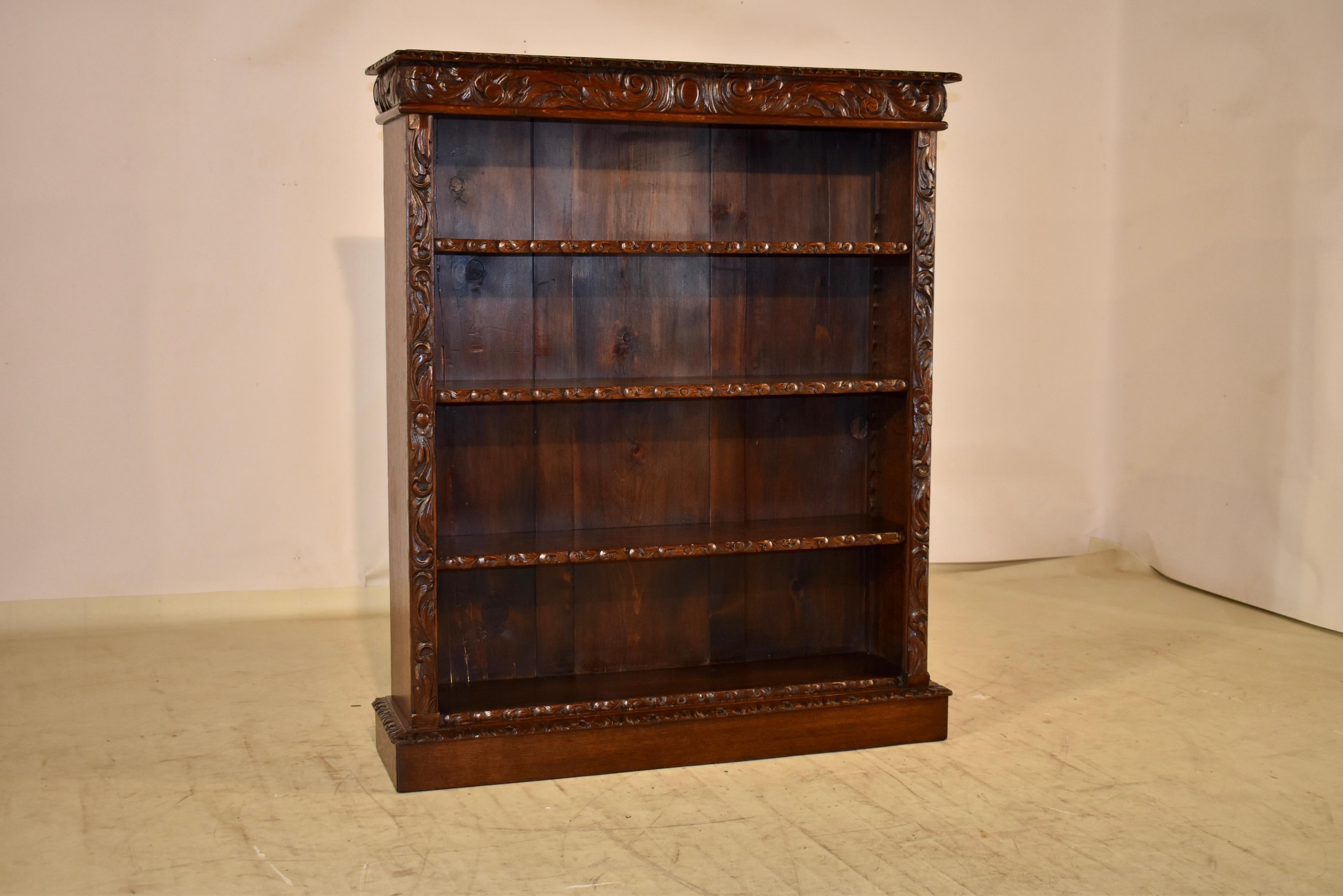 19th century oak bookcase from France.  The top has a beveled and hand carved decorated edge, following down to a carved upper band which extends to both sides for added design interest.  The piece has three moveable shelves, all with hand carved