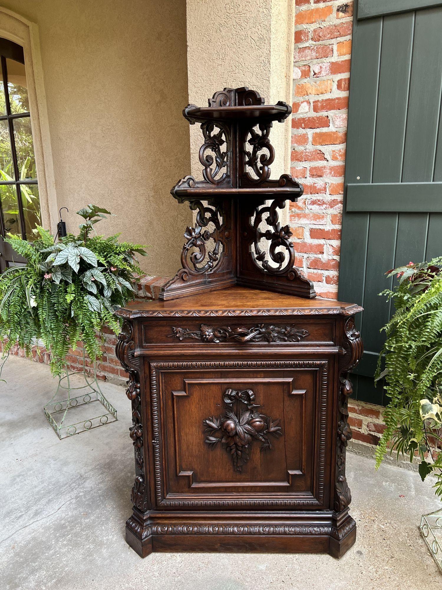 19th century French Carved Corner Cabinet Black Forest Open Shelves Bookcase.
 
Direct from France, a beautifully hand carved corner cabinet, almost 6 ft. tall, with upper open shelves, having large, hand carved scroll and foliate designs between