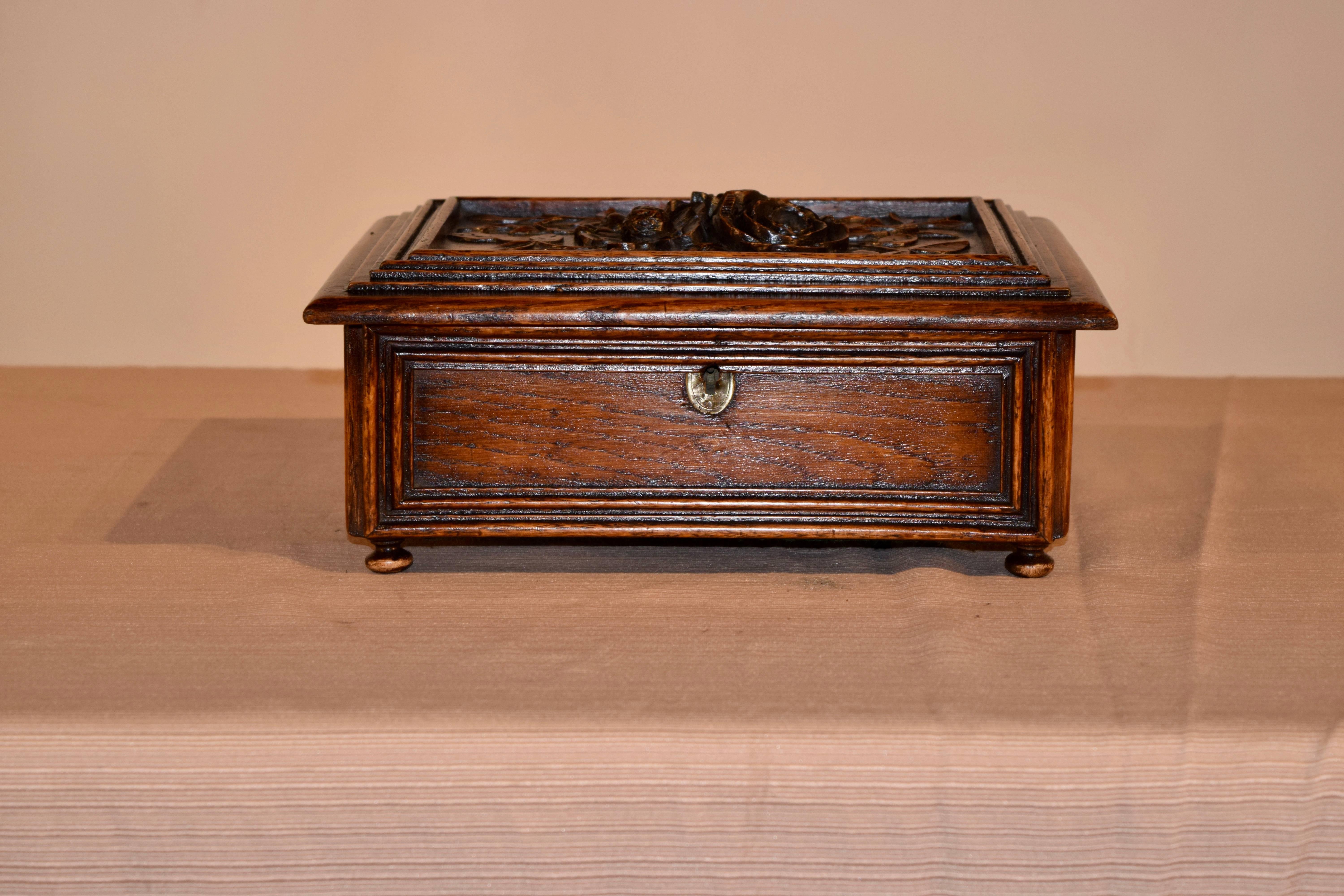 19th century French dresser box with exquisite carving. The top is framed with a molded border and surrounds a central area with hand-carved flowers and leaves. The sides are also bordered with lovely molded edges, and the box is supported on hand