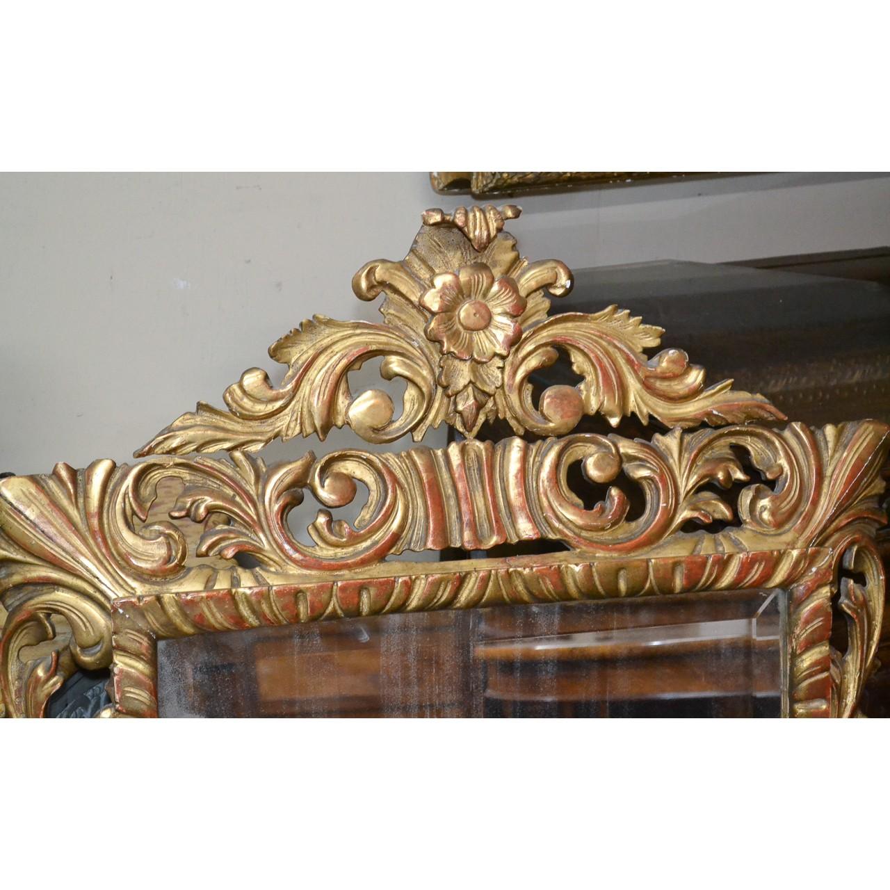 Outstanding 19th century French giltwood wall or console mirror. The finely carved gold-gilded frame with reddish highlights and ornately decorated with flower heads and scrolling acanthus leaves. Retains the original bevelled mirror,

circa 1880.