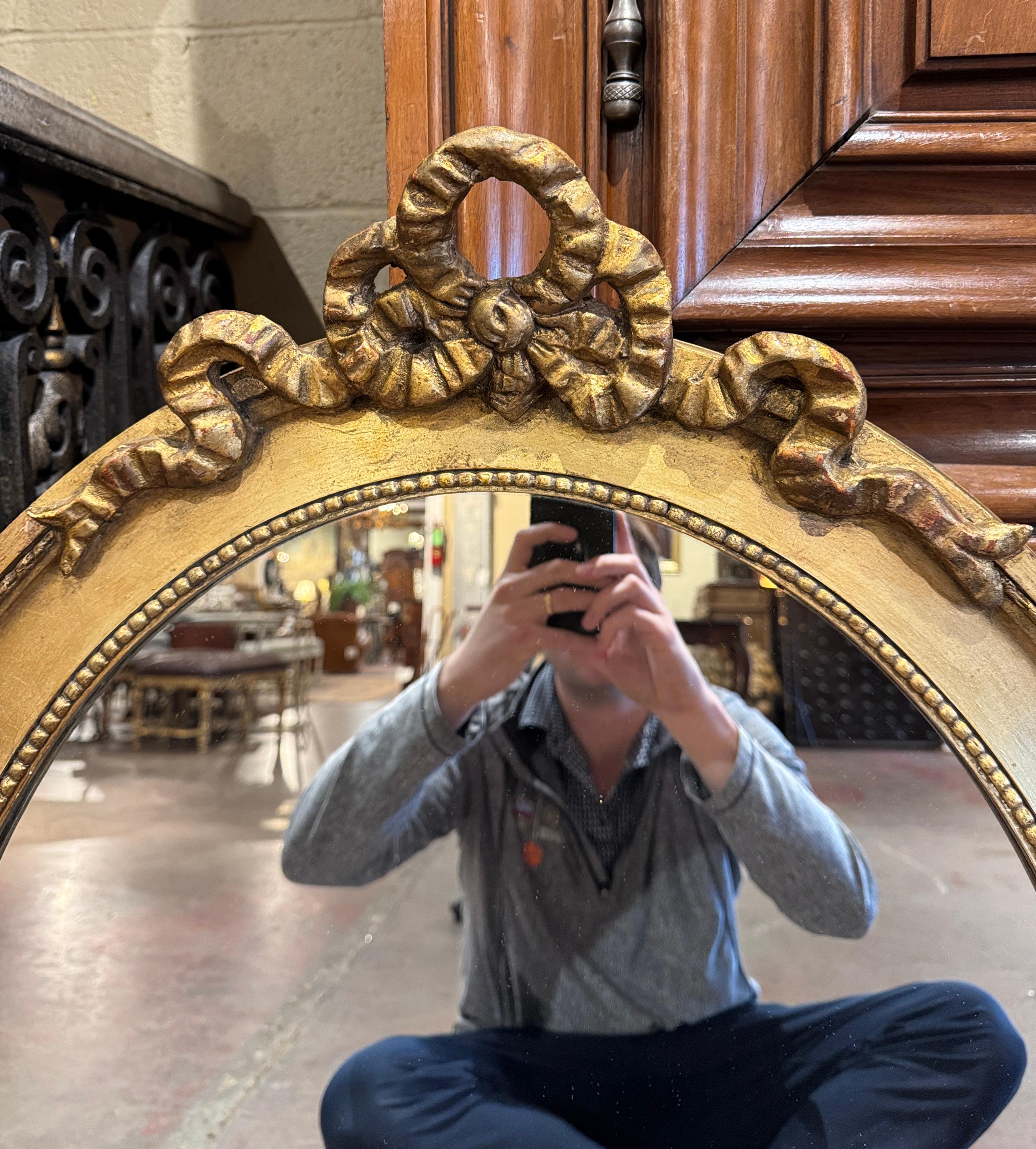 Francese Specchio da parete ovale in legno dorato intagliato del XIX secolo con arco a nastro Luigi XVI in vendita