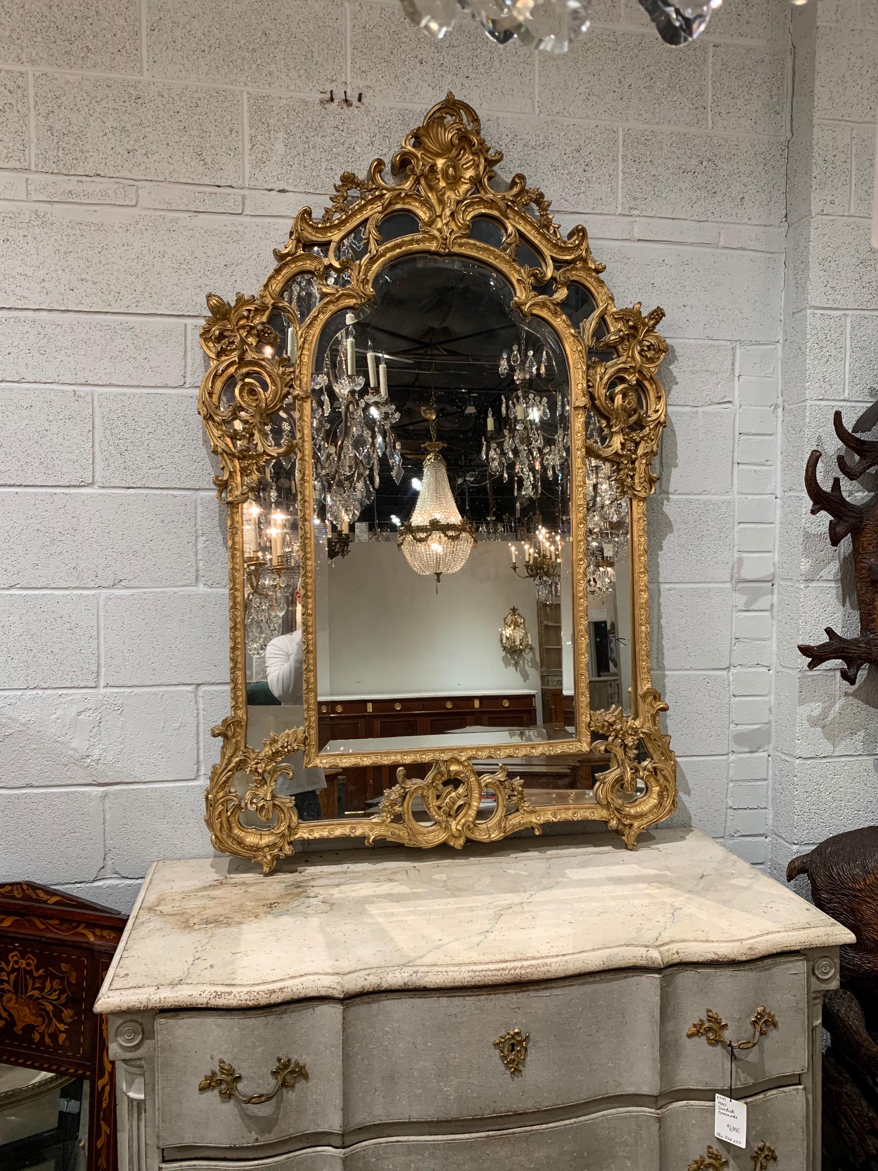Fabulous 19th century French carved giltwood Rococo mirror. Superb carvings of floral images, scrolls and an elaborate crest at the top. A truly impressive work of art!