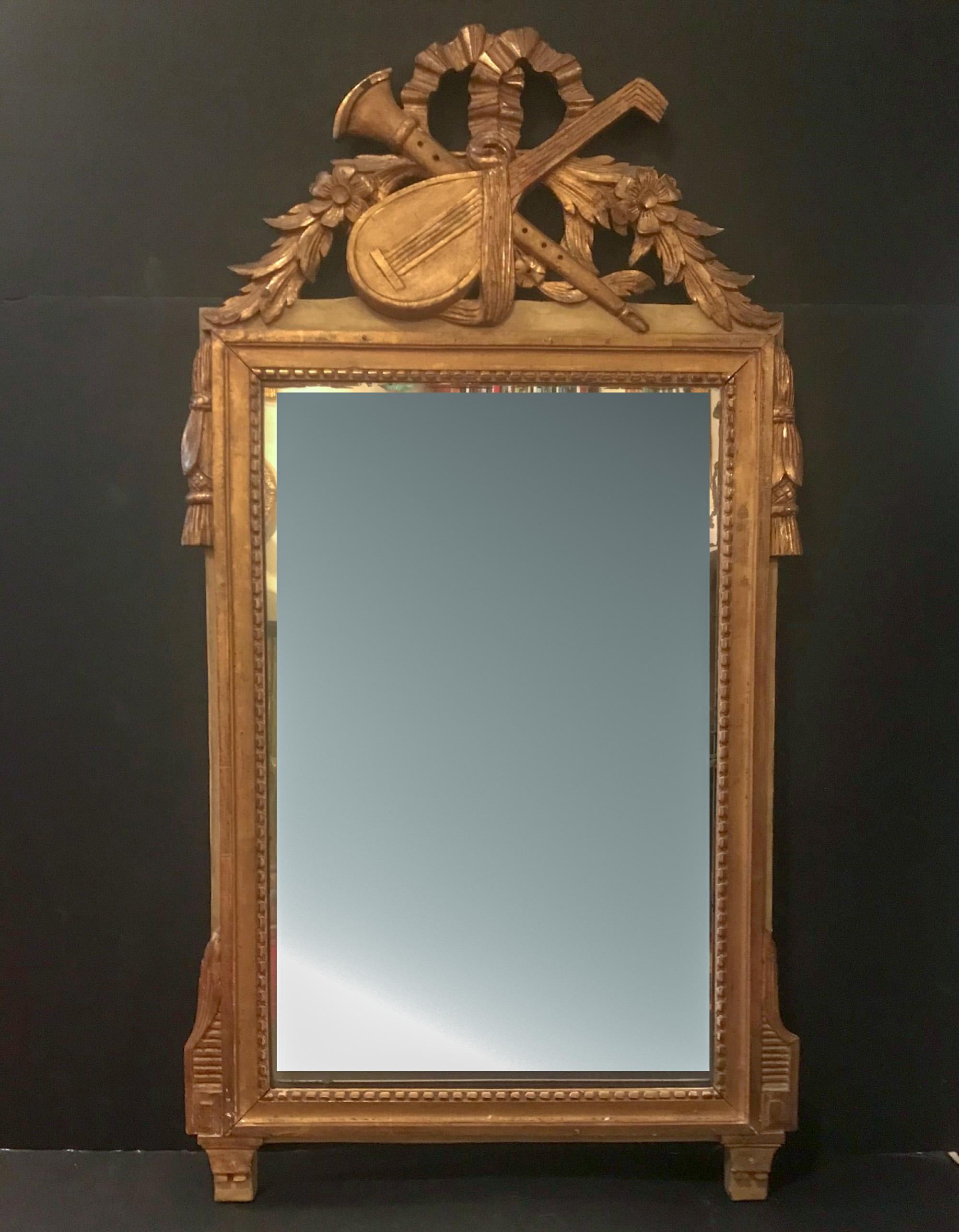19th century French hand carved Louis XVI style musical instruments giltwood mirror

A beautifully detailed and fine carving in the French Louis XVI style giltwood wall mirror. The mirror features musical instruments, a lute and a horn crossed and