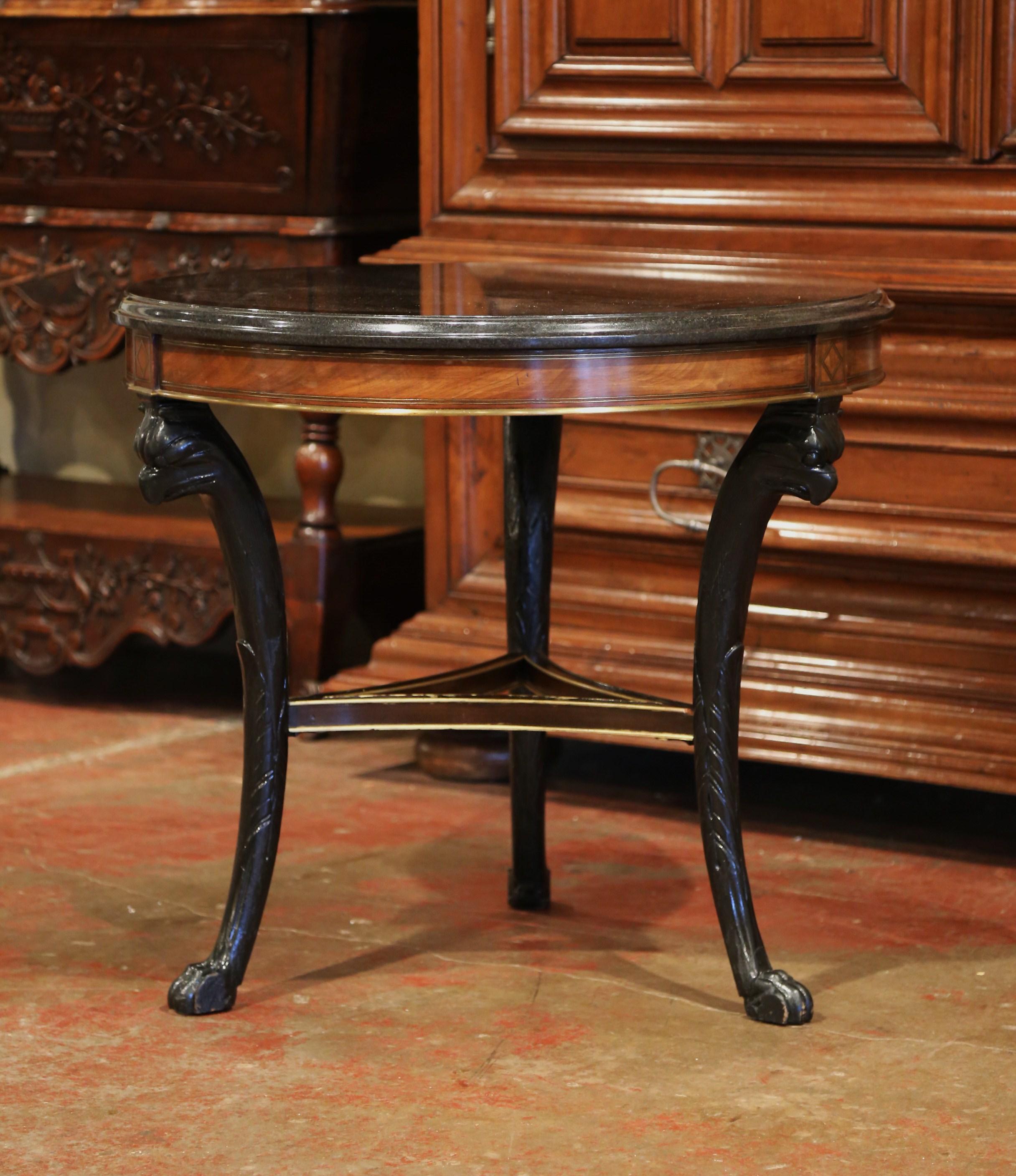 Place this antique round centre table in your entry or between two fauteuils. Crafted in France, circa 1860, the Napoleon III gueridon is carved in mahogany wood with an ebonized finish. The side table stands on three curved legs finished with paw