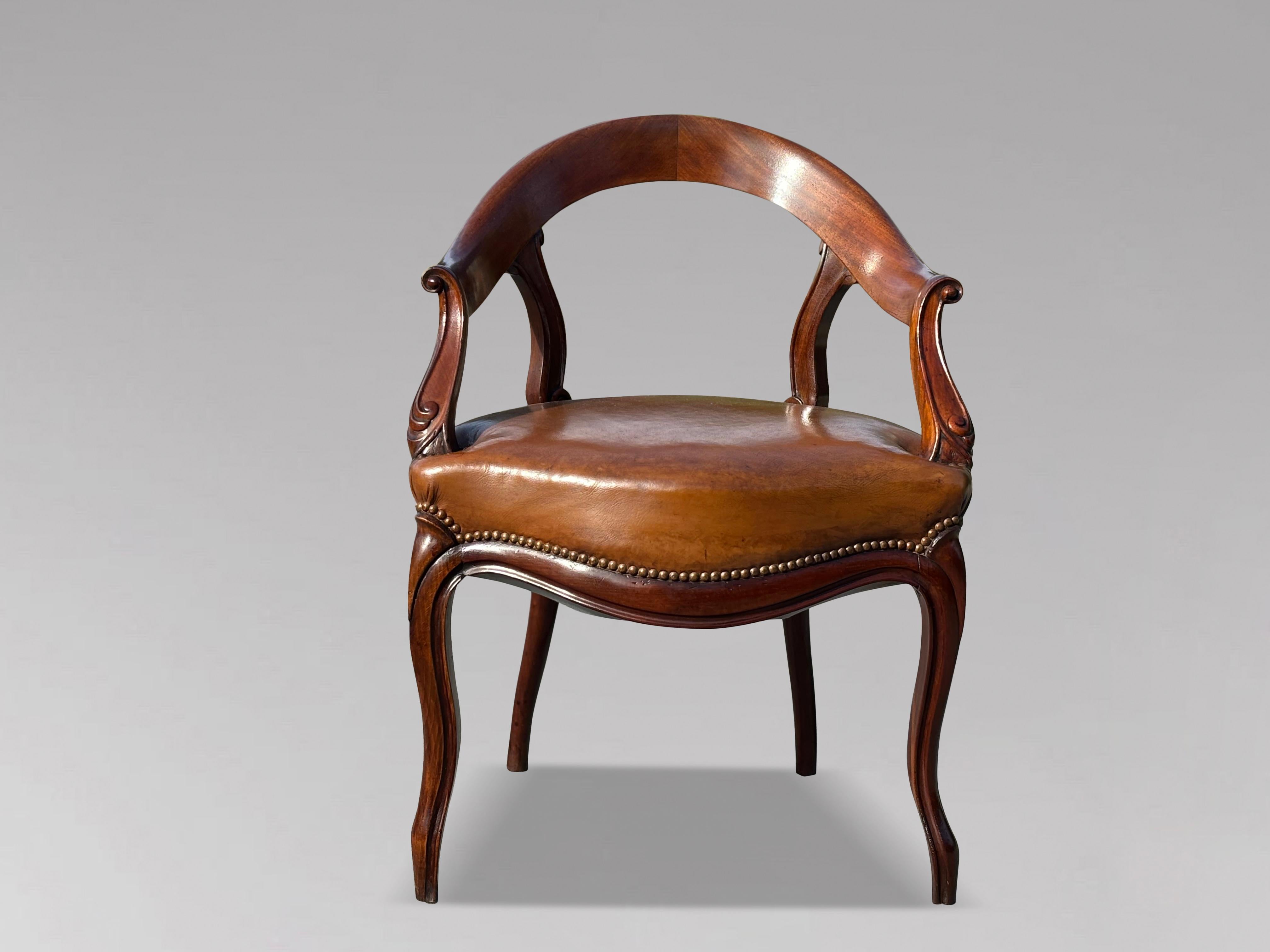 Questa sedia da scrivania intagliata in mogano e rivestita in pelle marrone della fine del XIX secolo presenta dei bellissimi braccioli intagliati a scorrimento.
La sedia è sostenuta da prominenti gambe cabriole nella parte anteriore e da gambe
