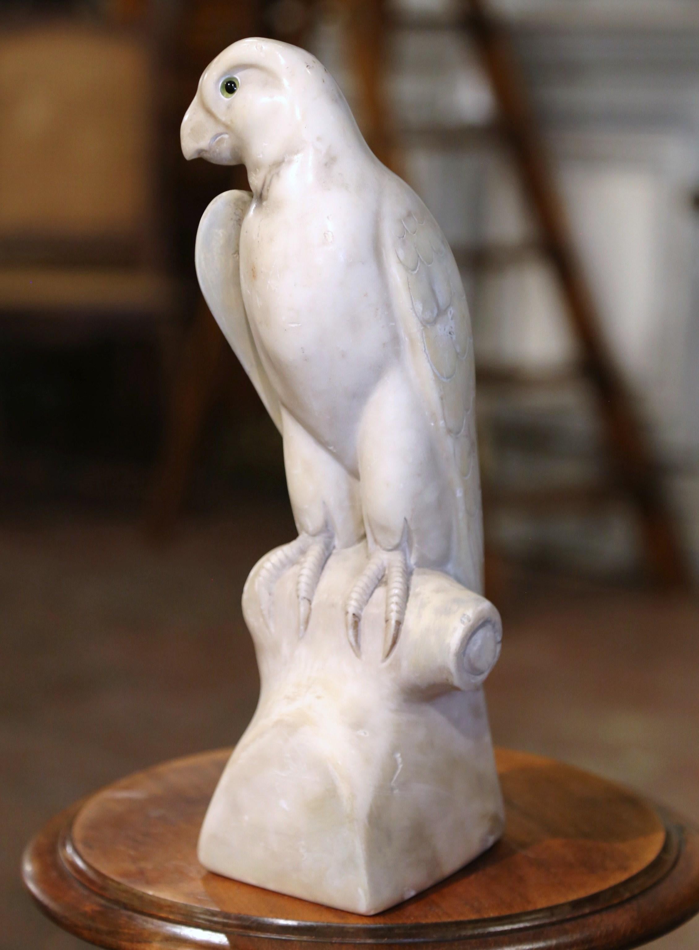 Decorate a shelf or a man's office desk with this stately antique marble parrot sculpture. Created in France circa 1880, and carved of white marble, the figure stands on an integral rectangular base, and depicts a proud bird perched on branch with