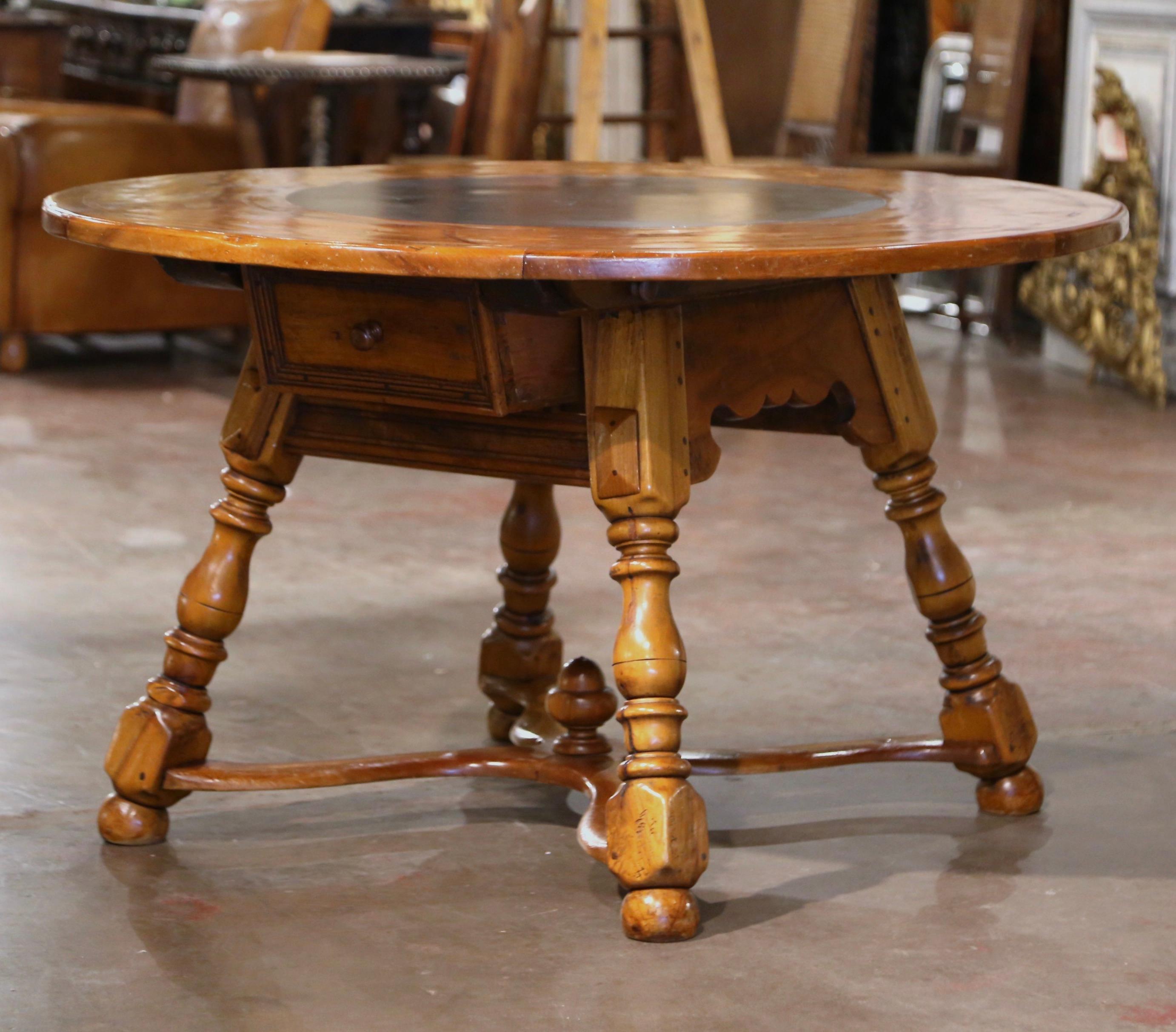 This elegant four foot round table was crafted in France circa 1880. Built of walnut, the table stands on four hand turned legs, connected at the base with an X-shape stretcher. The intricate 2