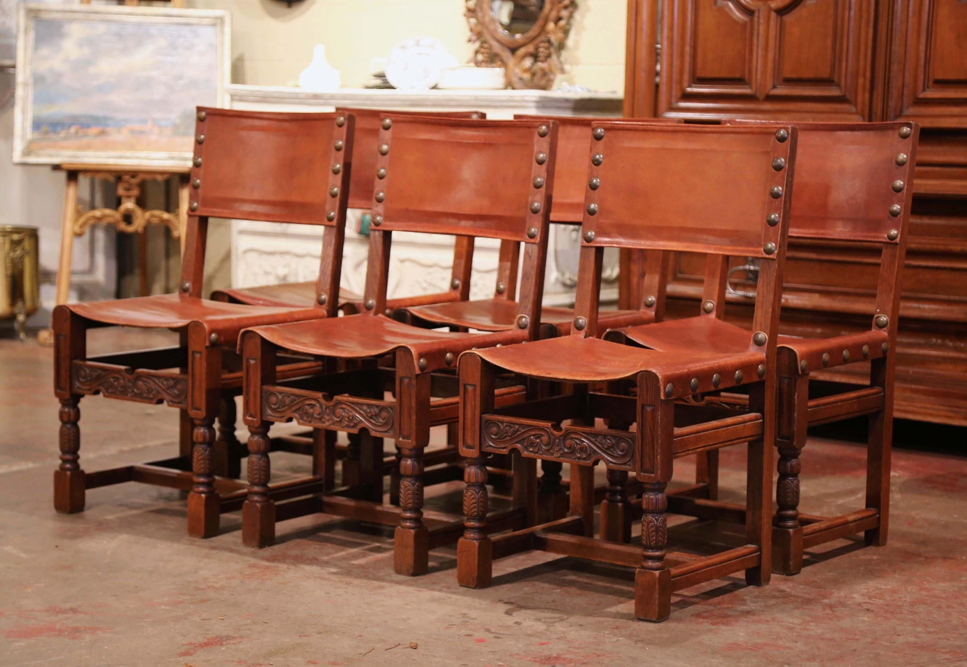 Decorate a breakfast room or game room table with this elegant set of antique chairs; crafted in France circa 1880 and built of oak wood, each chair stands on turned legs decorated with acanthus leaf motifs over a carved apron with floral decor. The