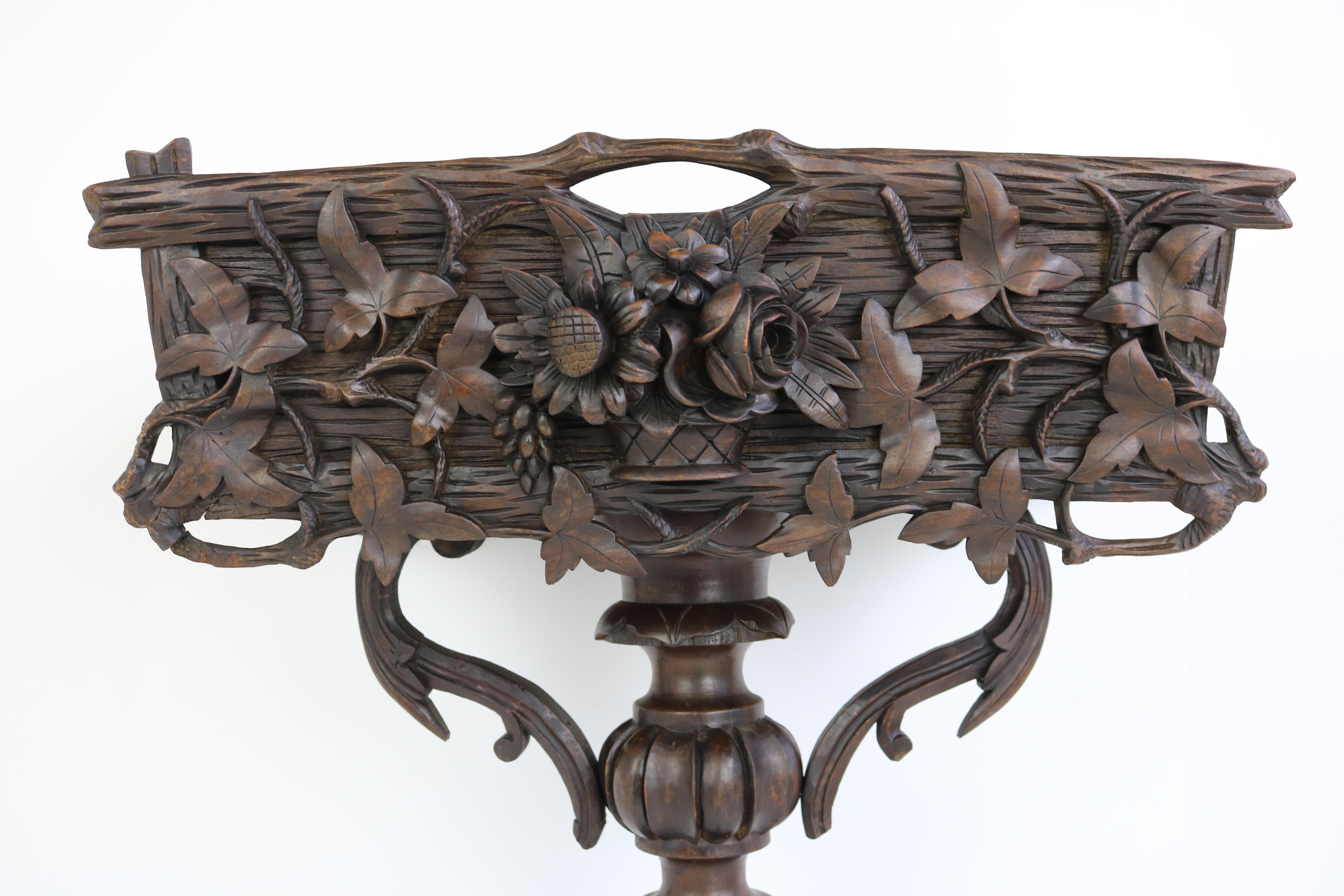 Gorgeous fully hand carved Black Forest 19th century plant stand / jardiniere in hand carved Fruitwood. 
The stand body has outstanding carvings with the center a dimensional carved bouquet of roses/flowers that extends 2” beyond the basket side.