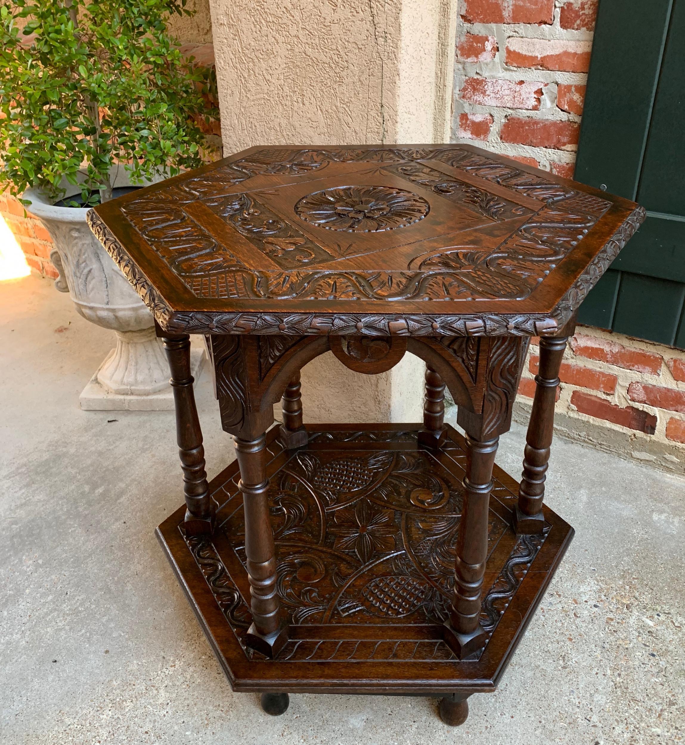 19th century French carved oak center side table hexagon two-tier with lower shelf.

~Heavily carved antique French oak center table~
~Striking hexagon shaped upper and lower tier, each completely carved~
~Scalloped, arched and carved apron above