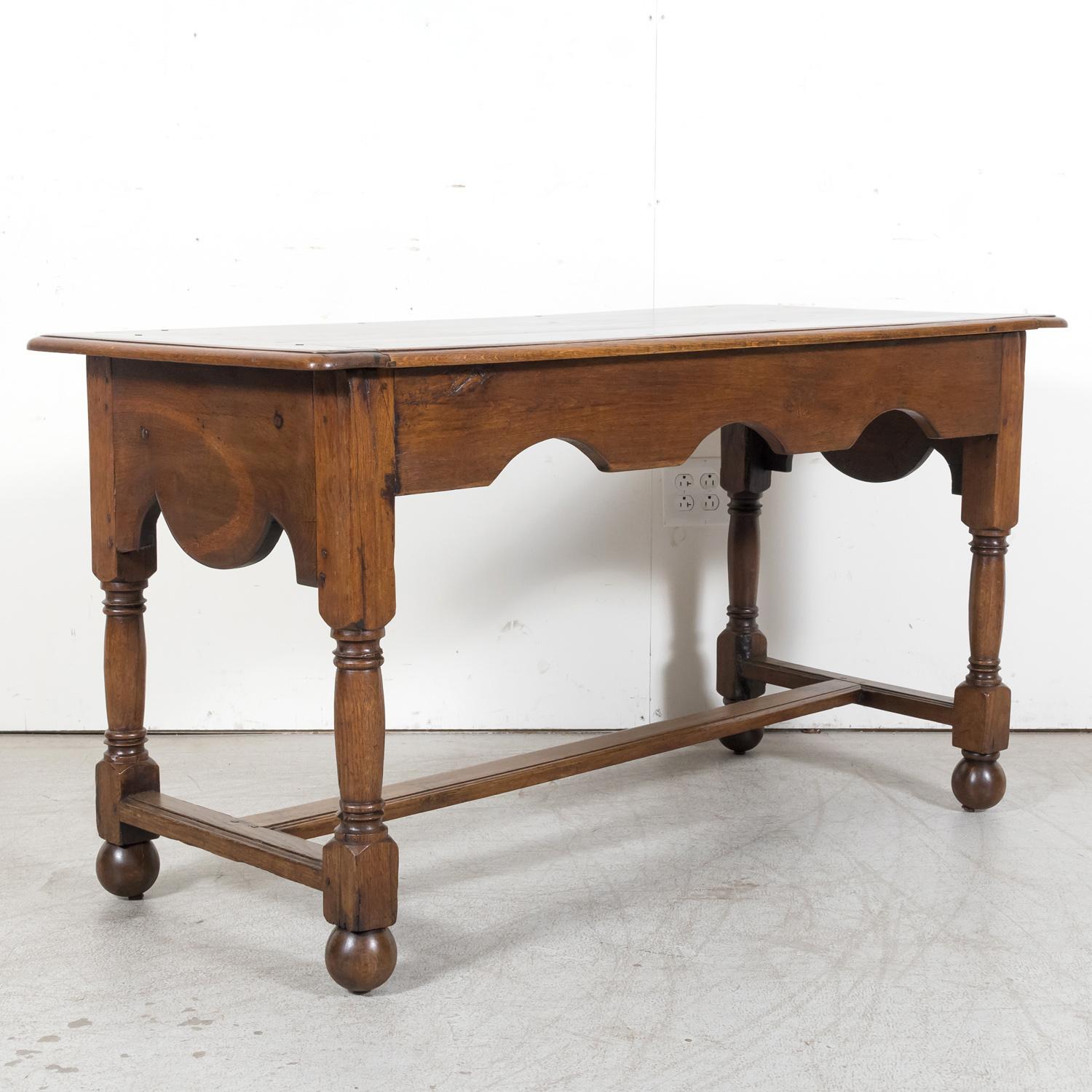 A mid-19th century French Louis Philippe period console or library table, handcrafted of solid oak near Etretat, a picturesque seaside town situated on the Alabaster coast in Normandy, circa 1830s. Versatile in its functionality, this antique