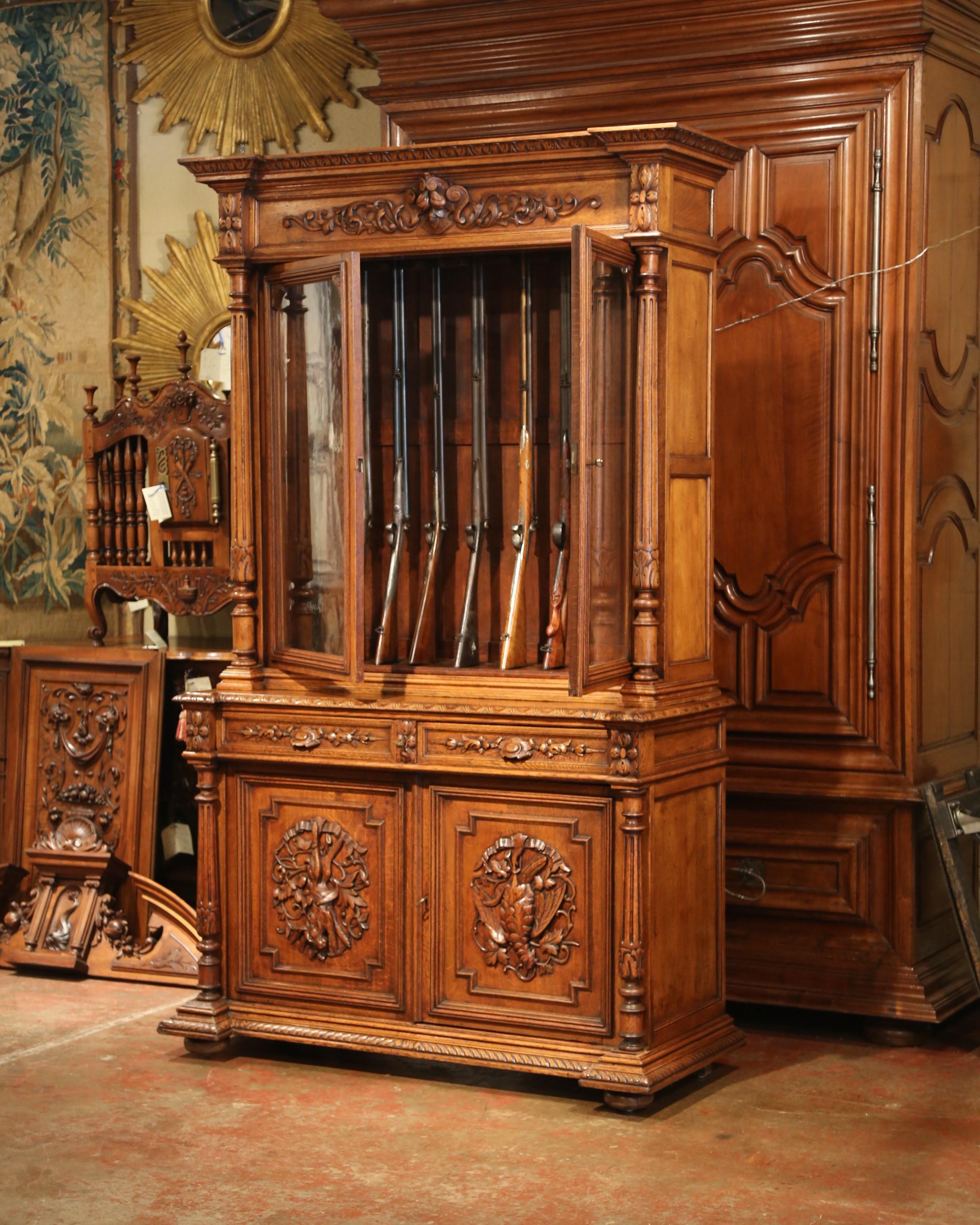 Store your rifle collection inside this beautifully carved, antique gun display cabinet. Created in France circa 1880, the two-piece buffet will hold up to nine guns. The cabinet has a pair of doors with original glass across the front, which are