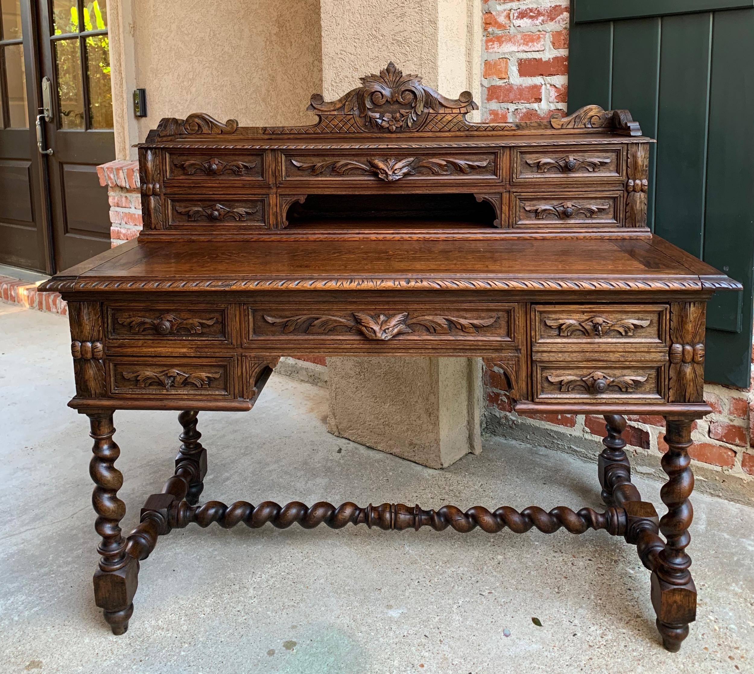 ~Direct from France~
A superb antique French oak desk with exquisite, opulent, ornate carvings!
~The upper desk has a beautiful carved crown with center ribbon/wreath and crosshatch above the full length display shelf. Below are five drawers and a