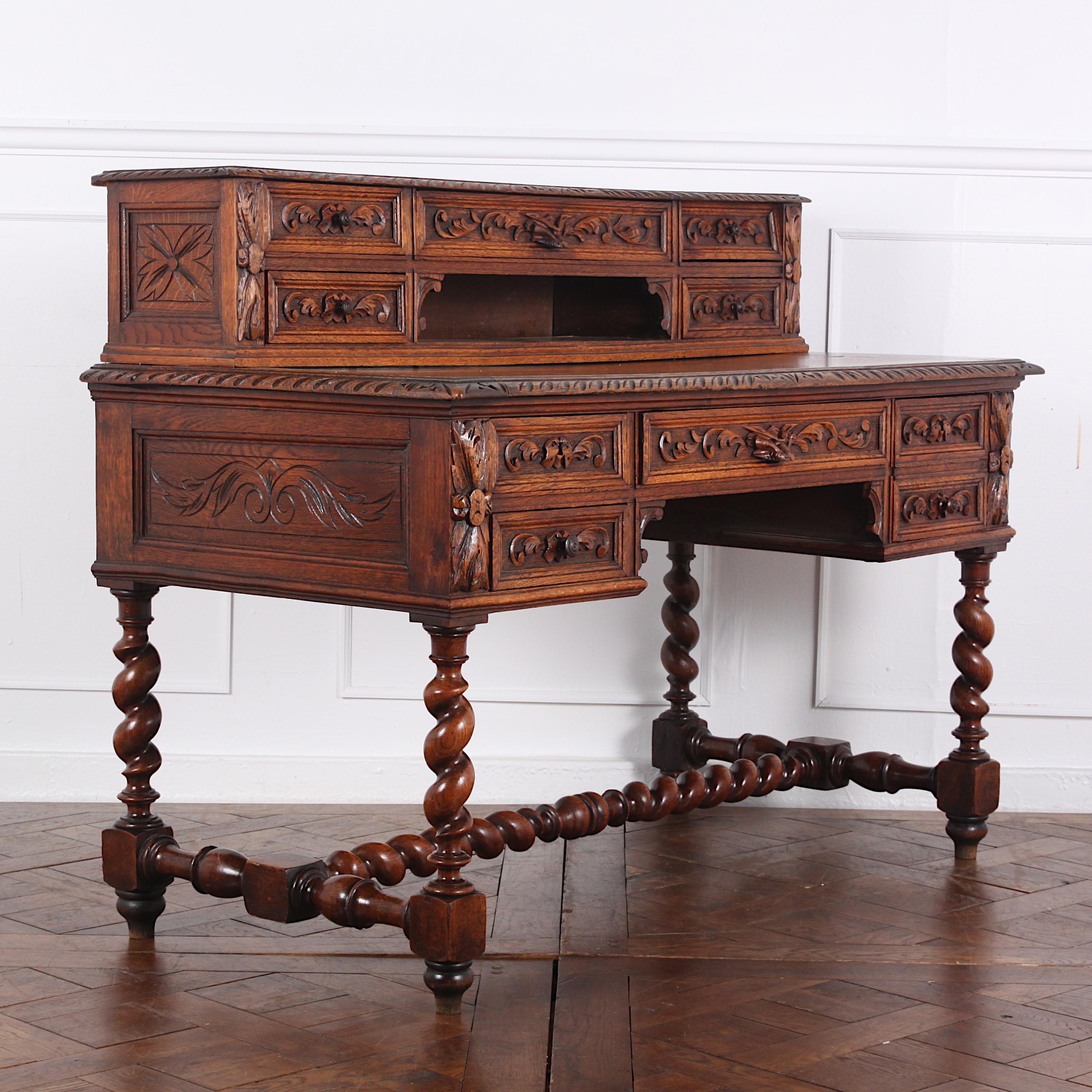A late 19th century heavily carved French ‘Henri II’ or Renaissance Revival style desk, the case with carved paneled sides and with five carved drawers. A further five smaller carved drawers are fitted to the upper superstructure. The desk sits on