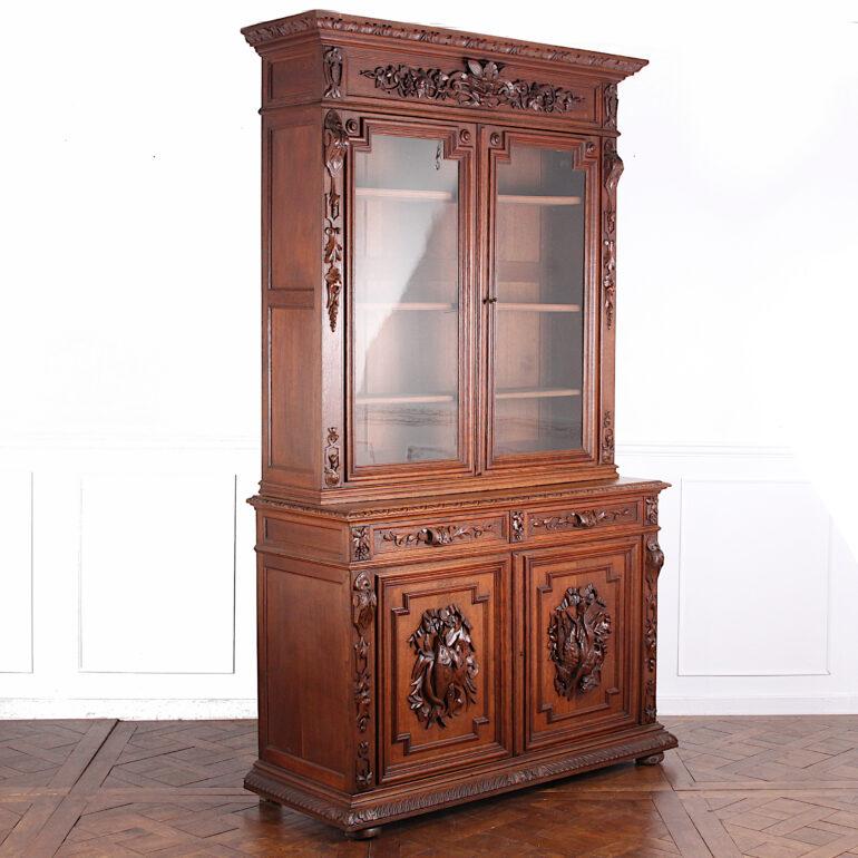 Impressive French carved oak Renaissance-revival bookcase with finely-carve ‘hunt’ motifs to the lower doors below carved drawers, the top with a pair of glass doors opening to adjustable shelves. Further carving to the pilasters flanking the doors
