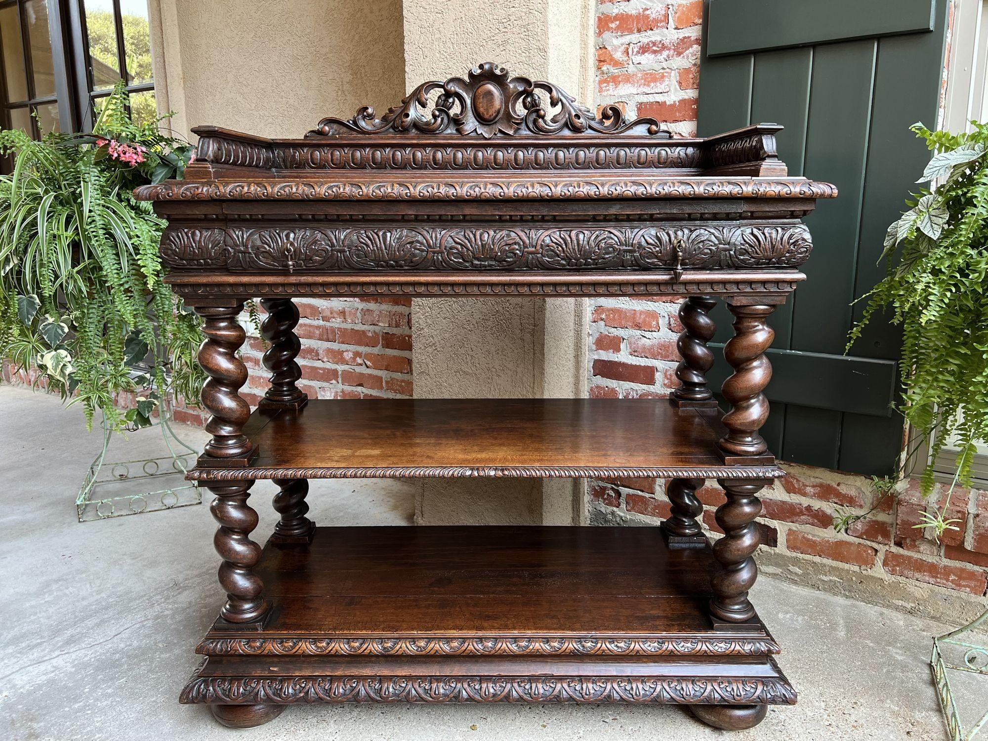 19th century French carved oak server sideboard barley twist wine buffet shelf.
 
Direct from France, a very special, highly carved, 19th century French server/sideboard! Gorgeous open carved back with center medallion over egg and dark carved