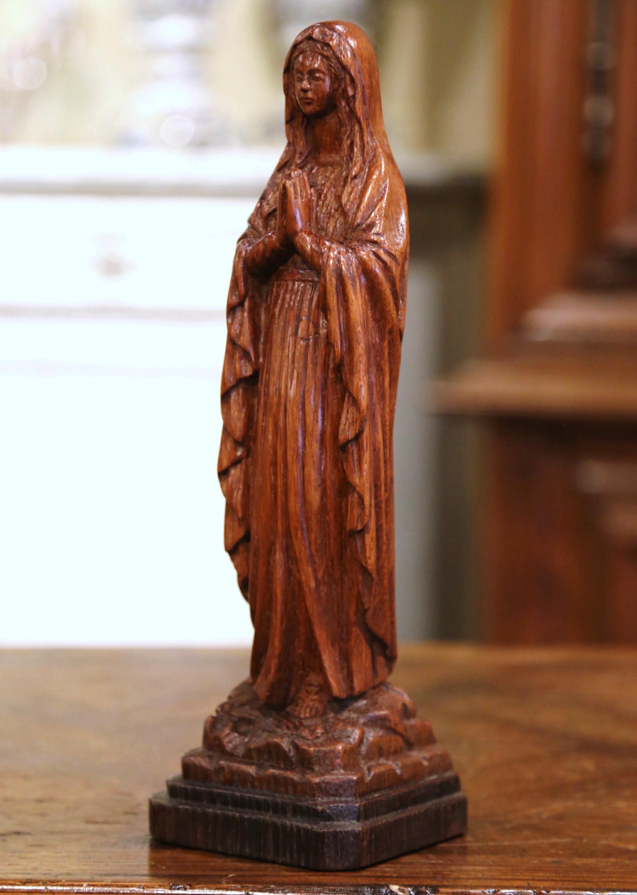 This elegant antique sculpture of Madonna was created in Normandy, France, circa 1880. Hand carved with wonderful details, the Classic figure standing on a square base with rocky ground, depicts the Mother of our Lord Jesus Christ in prayers with